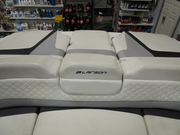 2017 Larson 292 LXI boat interior with white quilted seating in a store setting.