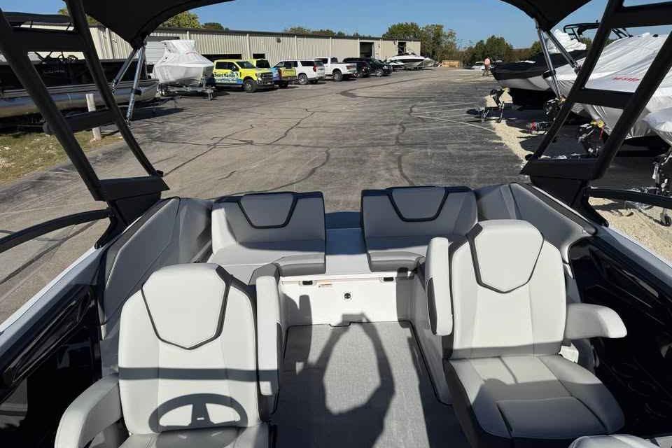 2026 Yamaha Boats AR250 interior with modern seating, parked in a boatyard.