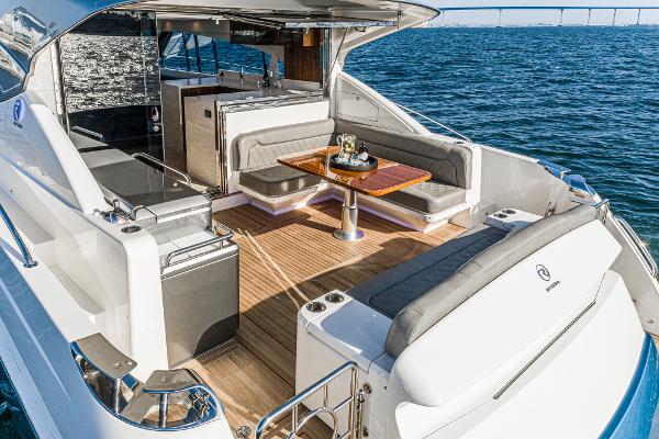 2021 Riviera 5400 Sport Yacht, luxurious deck with seating and dining area, on open water.