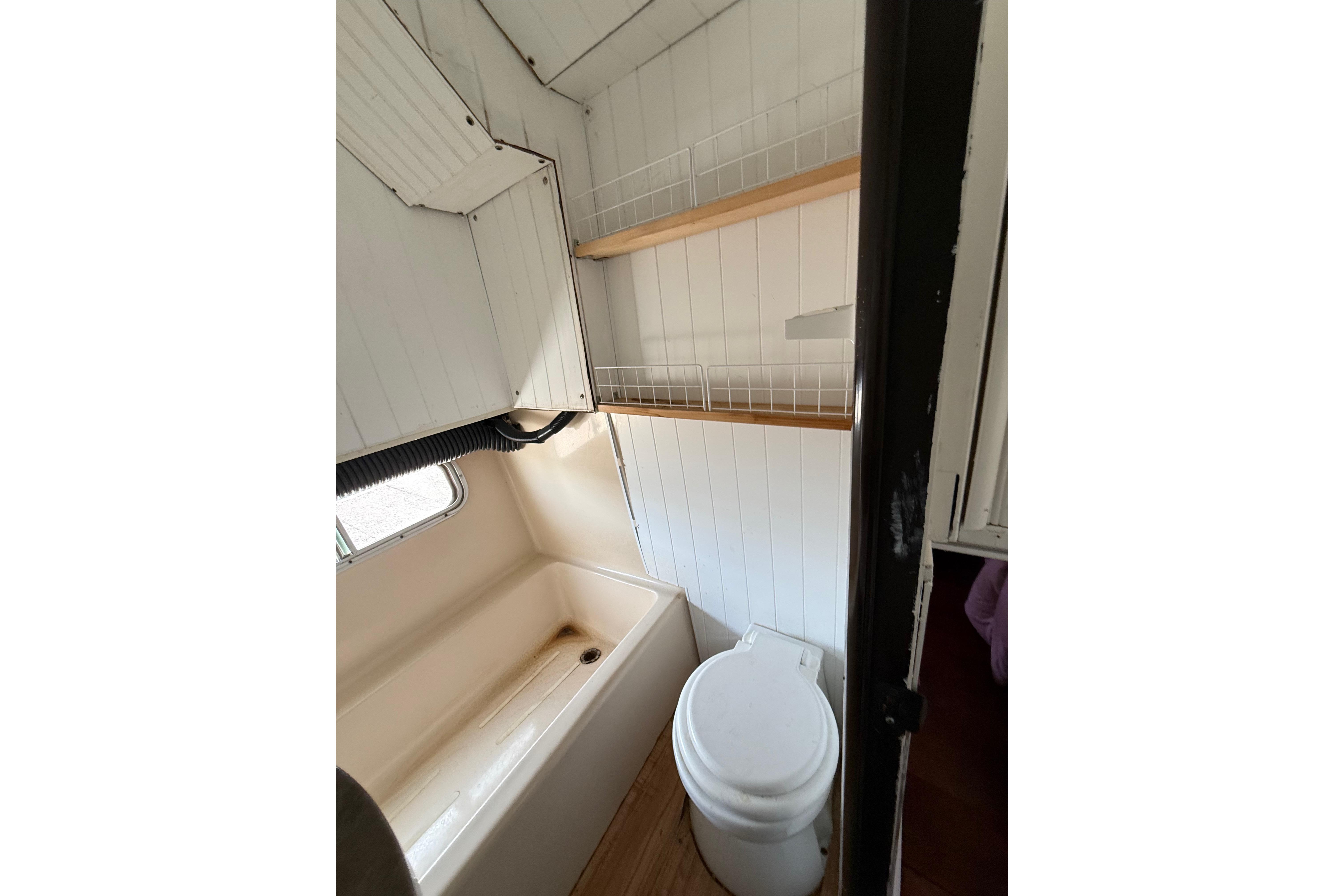 Compact bathroom in 1983 Holiday Mansion 37 Barracuda houseboat with tub and toilet.