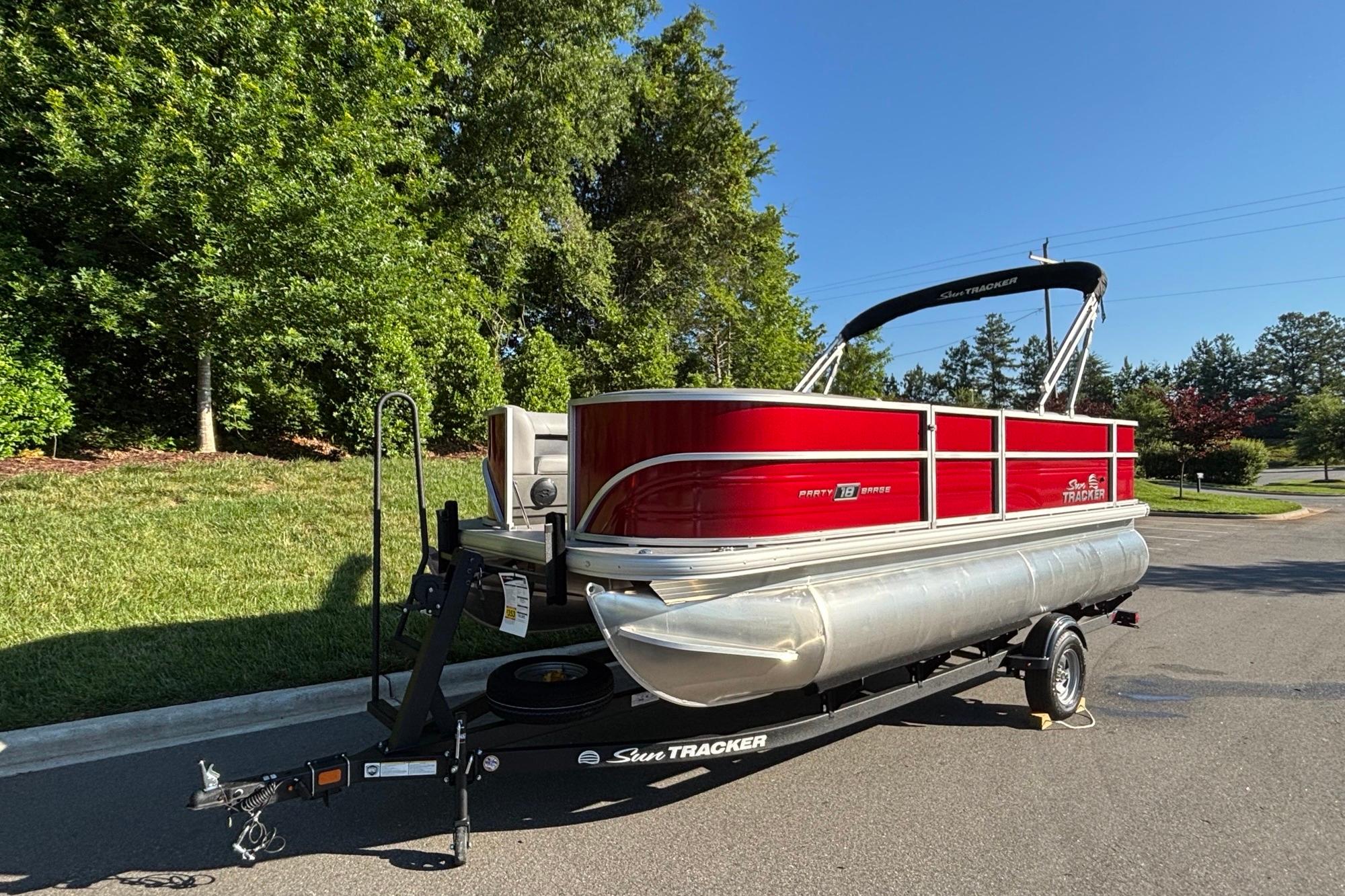 2026 Sun Tracker Party Barge 18 DLX pontoon boat on trailer, parked outdoors.