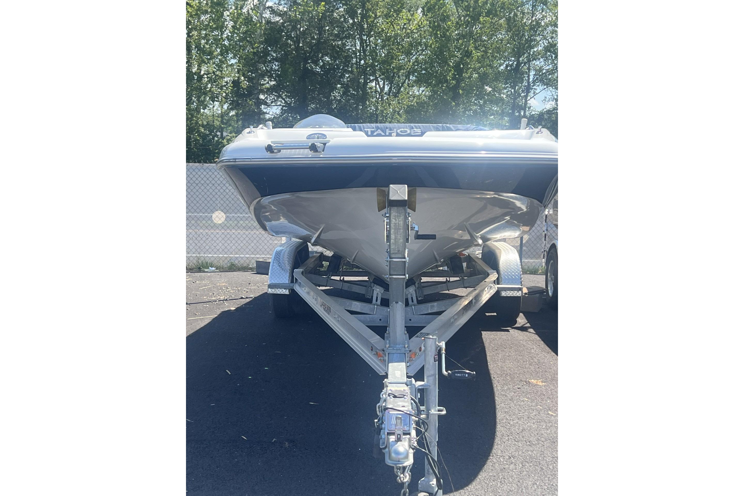 2017 Tahoe 2150 boat on trailer, parked outdoors with trees in background.