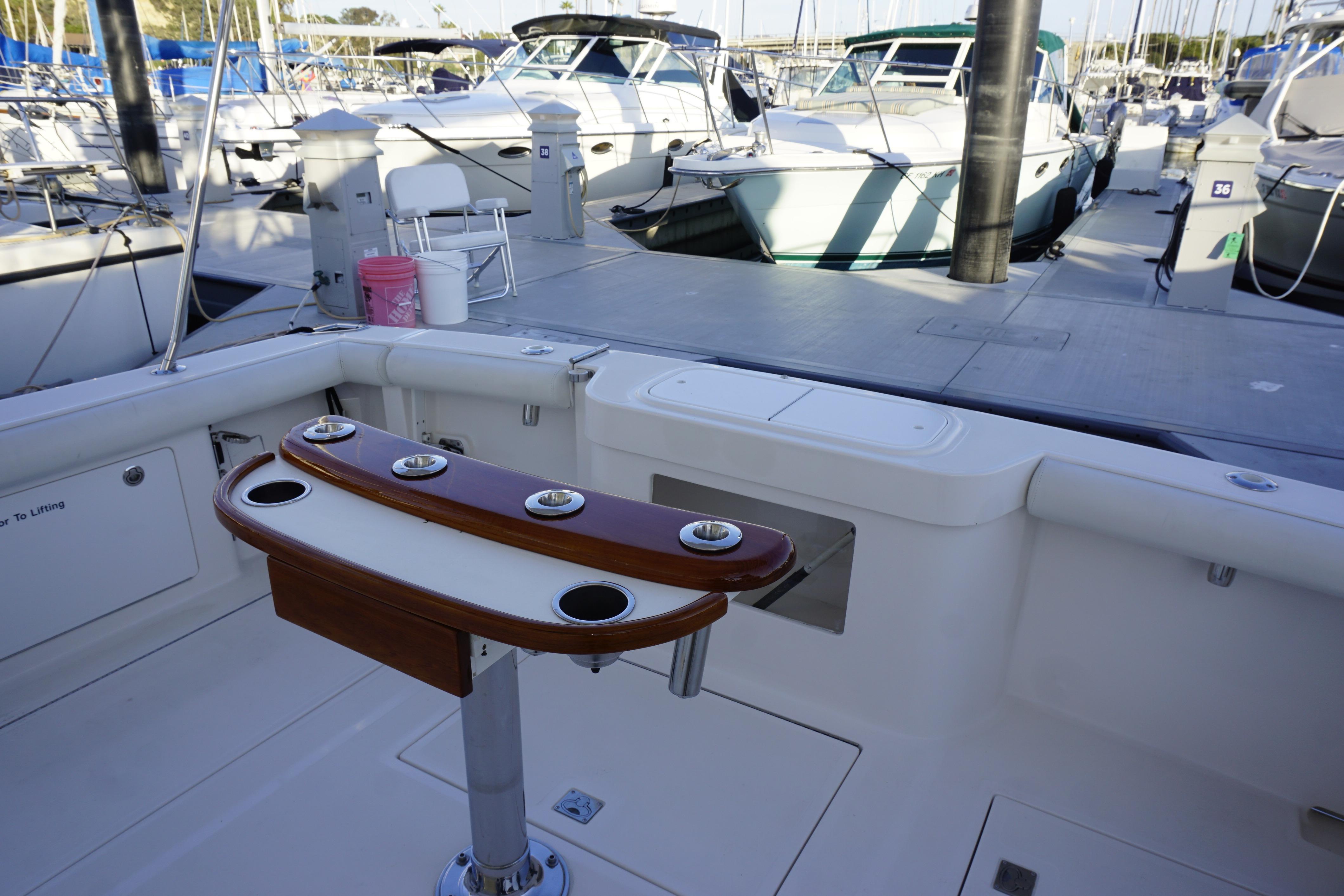 2005 Cabo 35 Express boat interior with fishing rod holders at marina.