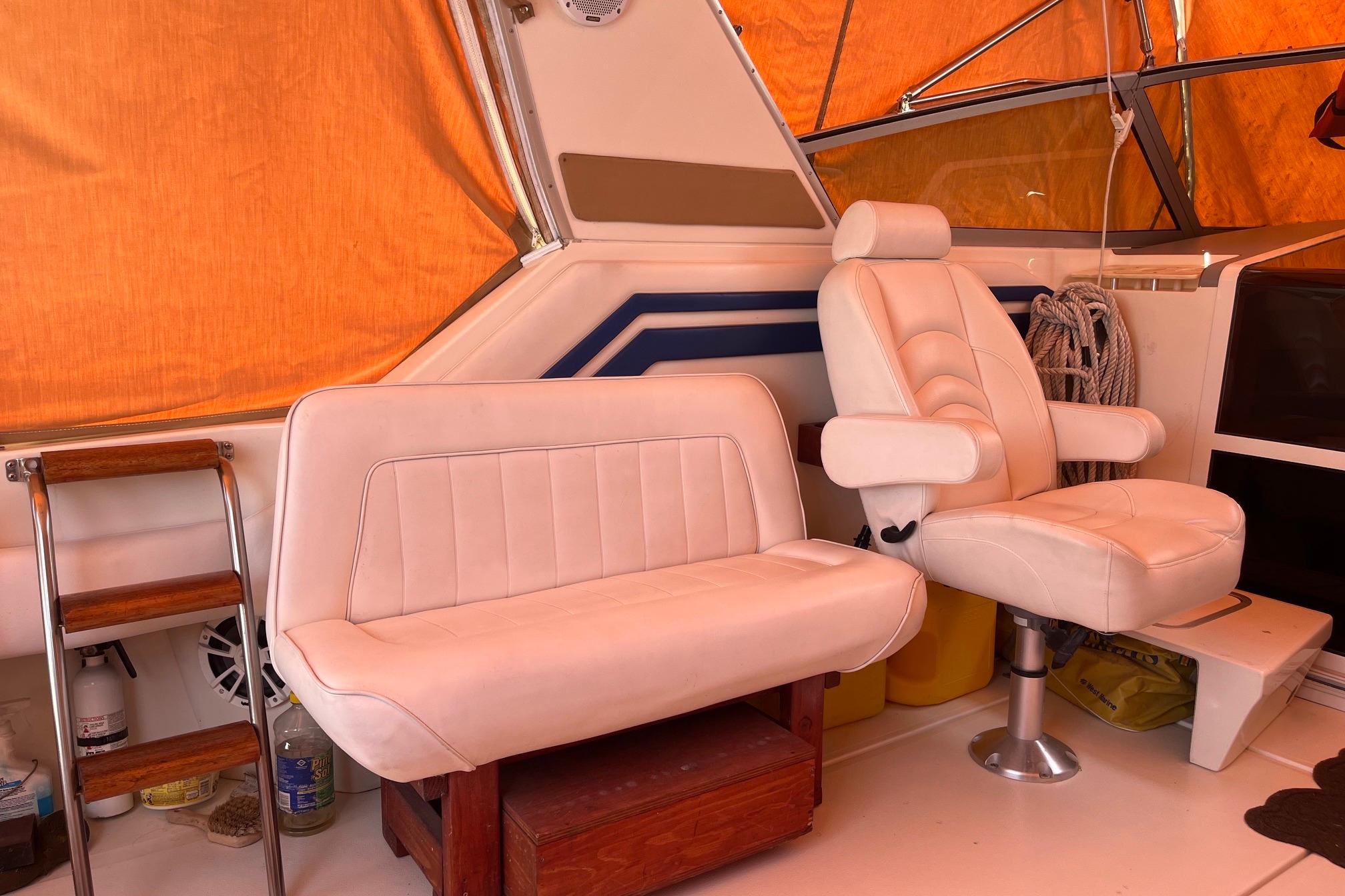 Interior of a 1994 Sea Ray 400 Express Cruiser with white seating and orange canopy.