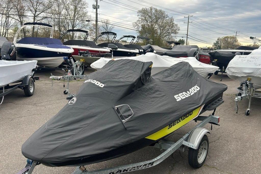 2014 Sea-Doo Wake Pro 215 covered on trailer, surrounded by boats in a lot.