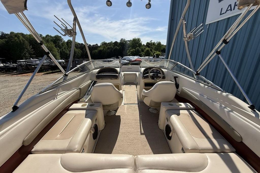 Interior view of a 1999 Glastron GT 225 boat with beige seating and steering wheel.