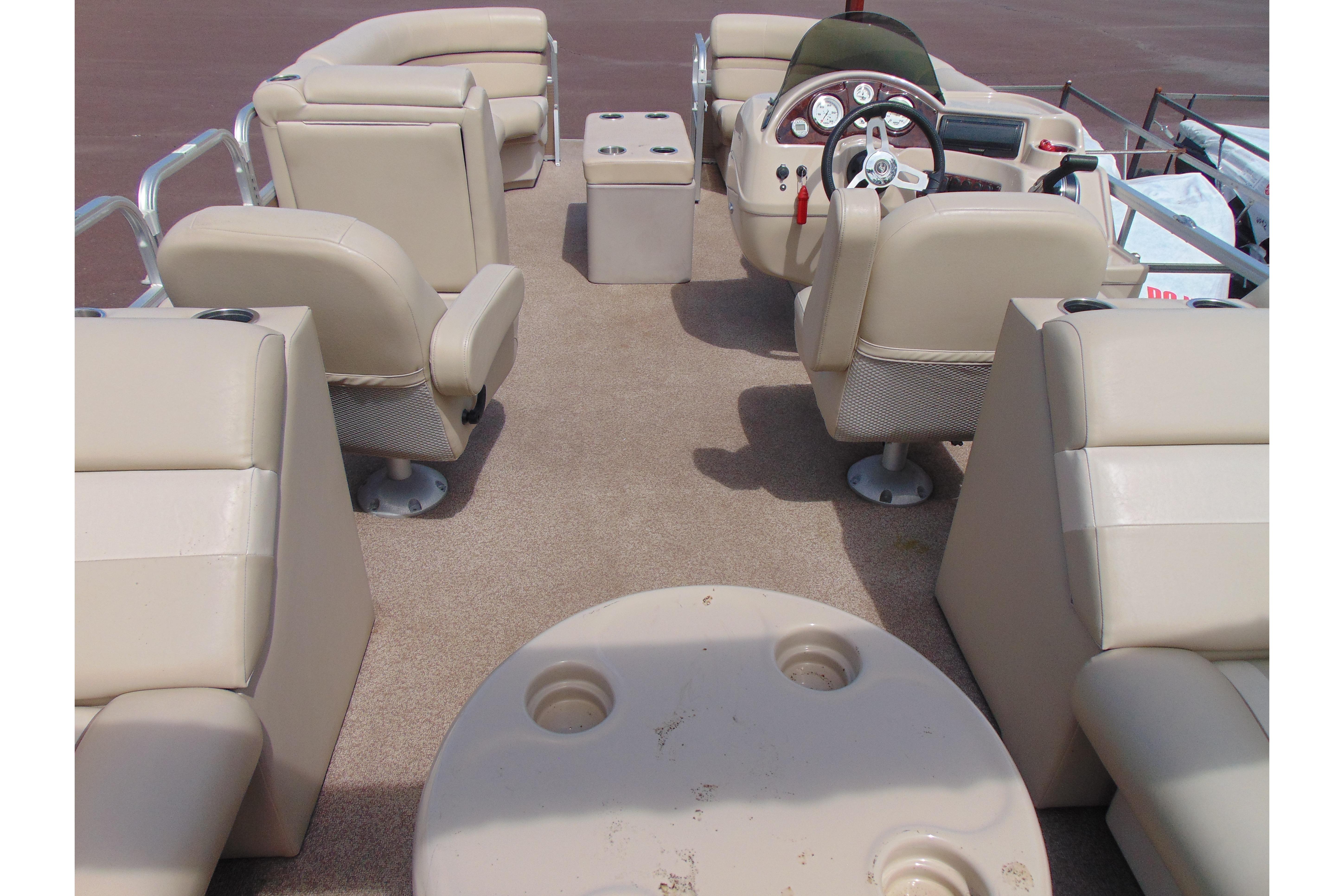 2016 Misty Harbor 245 Adventure CU pontoon boat interior with beige seating and steering console.