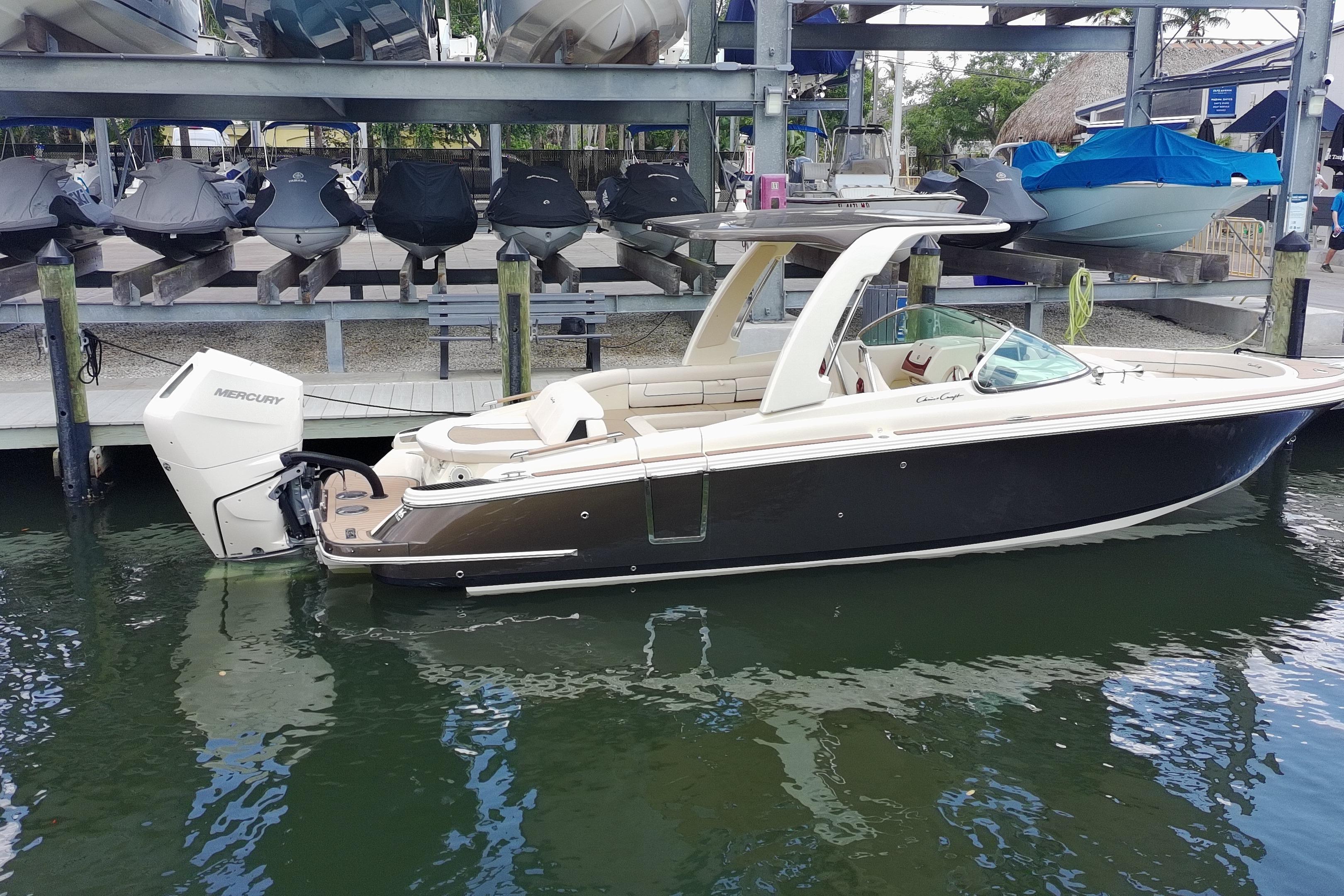 2024 Chris-Craft Launch 28 GT boat docked, featuring sleek design and Mercury outboard engine.