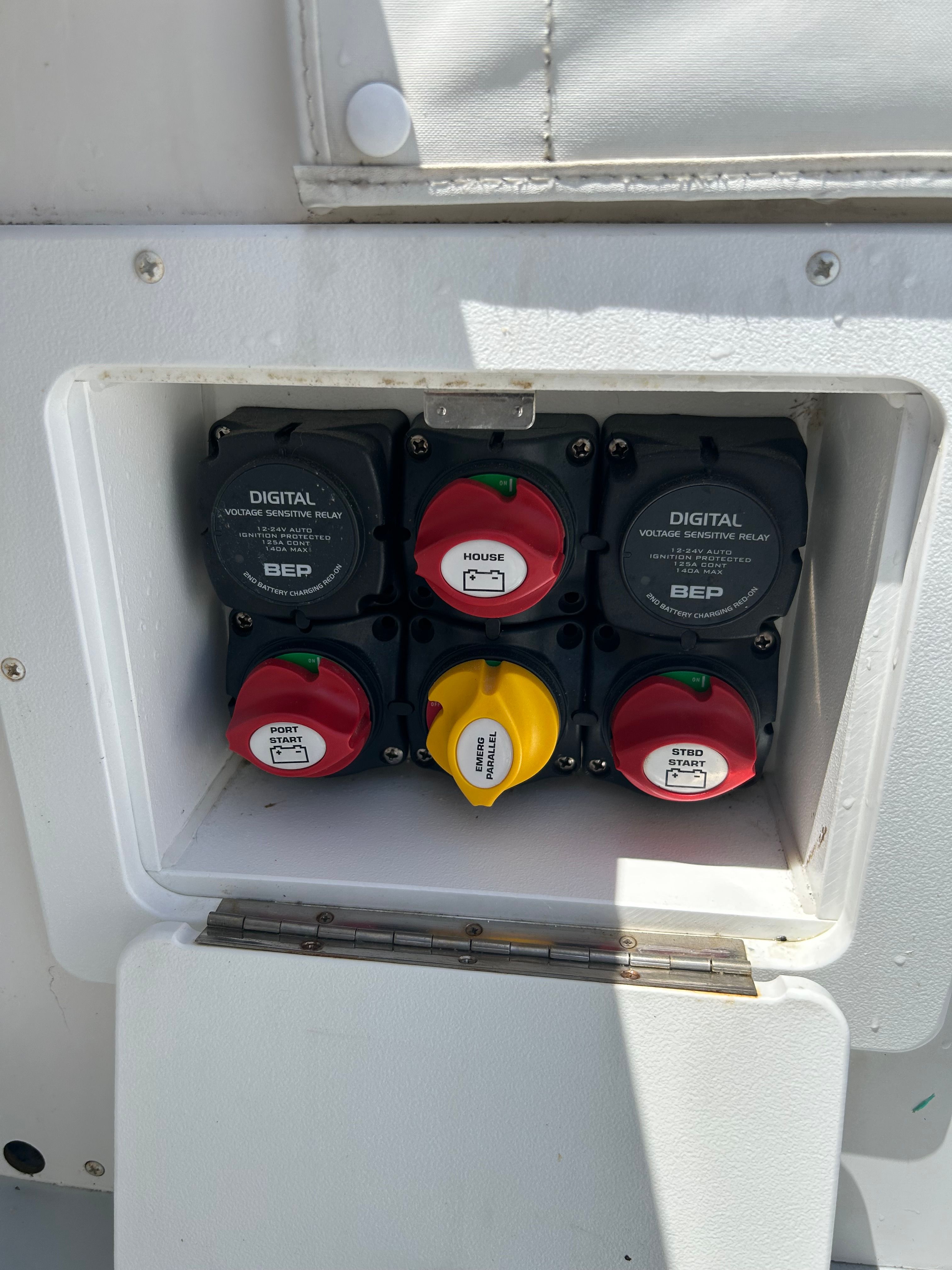 Electrical panel housing with multiple switches and gauges on a boat.