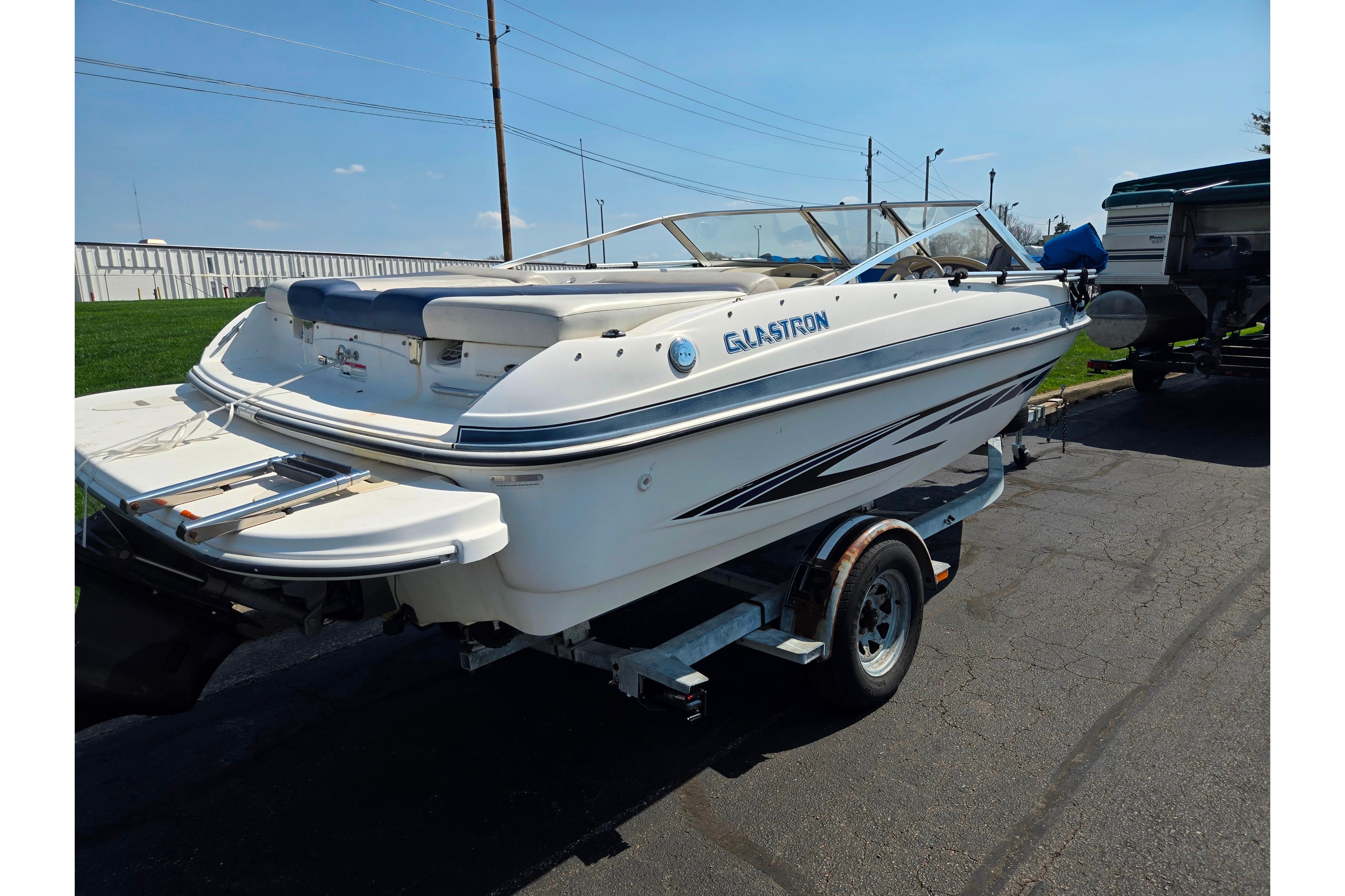 2007 Glastron GT 185 boat on trailer, parked outdoors under clear sky.