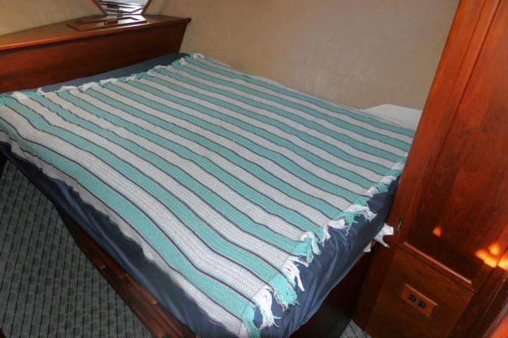 Cozy cabin bed with striped blanket in 1988 Jersey 36 Convertible Sportfisher.