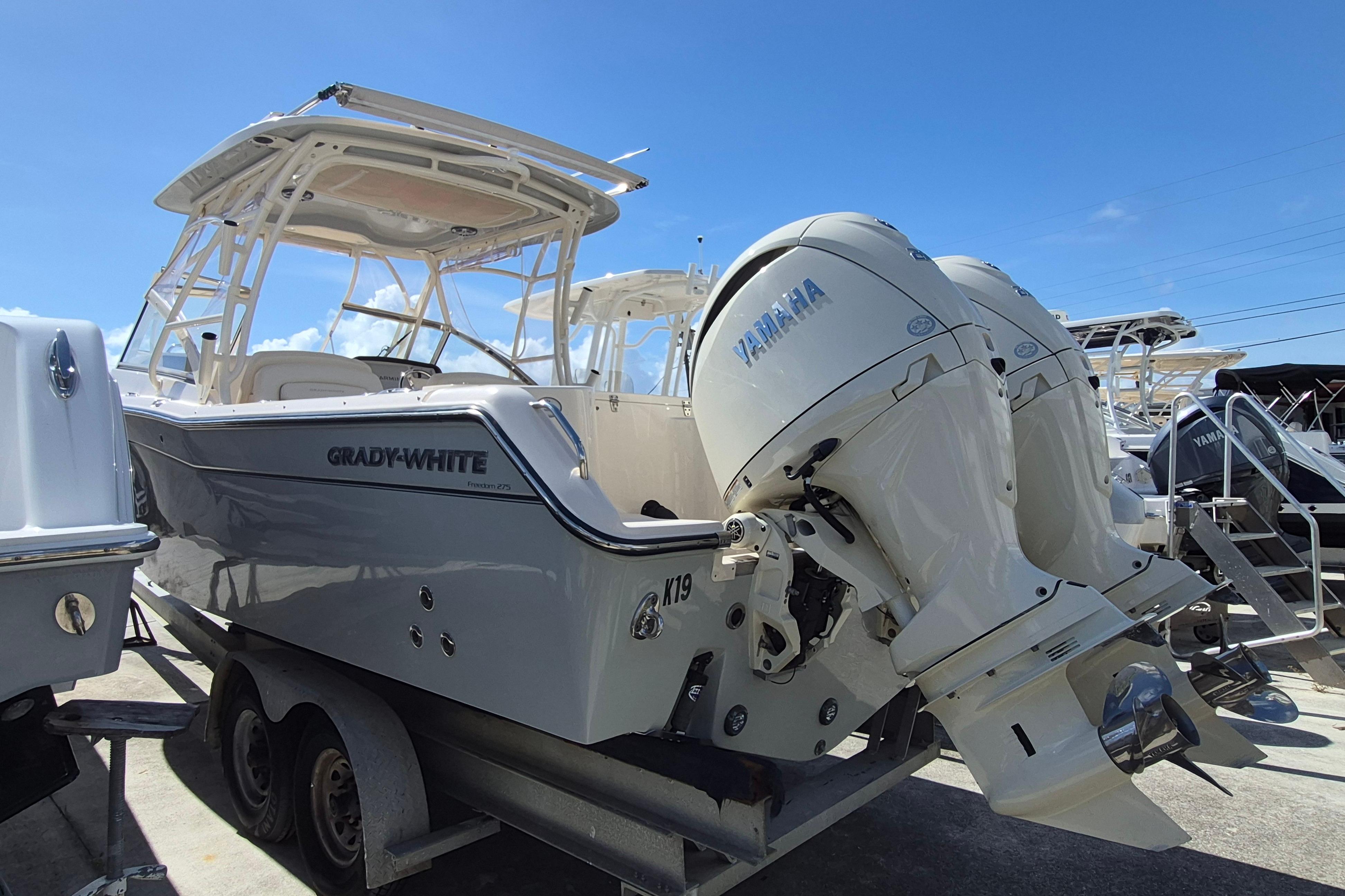 2025 Grady-White Freedom 275 boat with Yamaha engines, docked under clear blue sky.