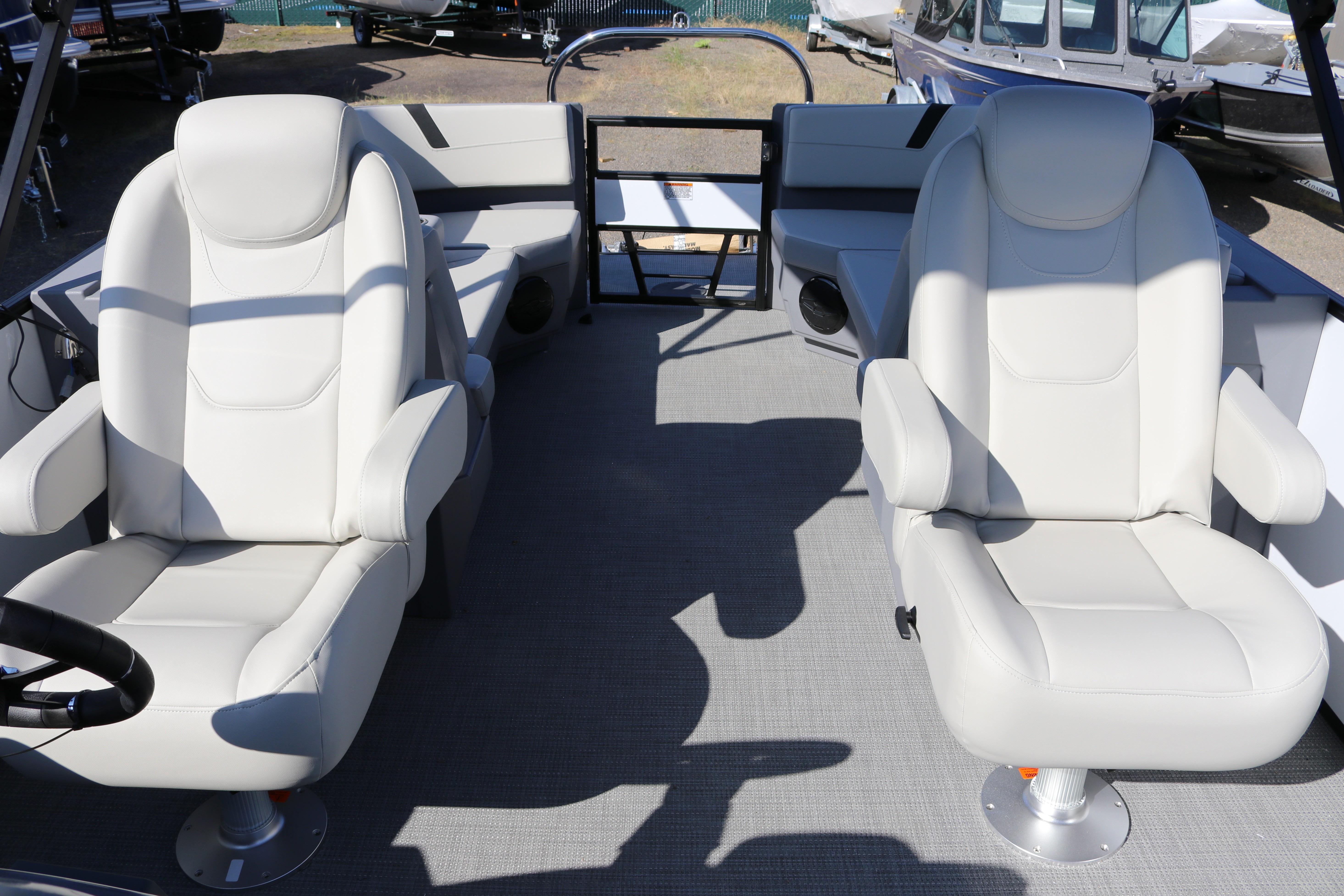Interior of 2025 SunChaser Lucerne 22 LR DH boat with two white captain chairs.