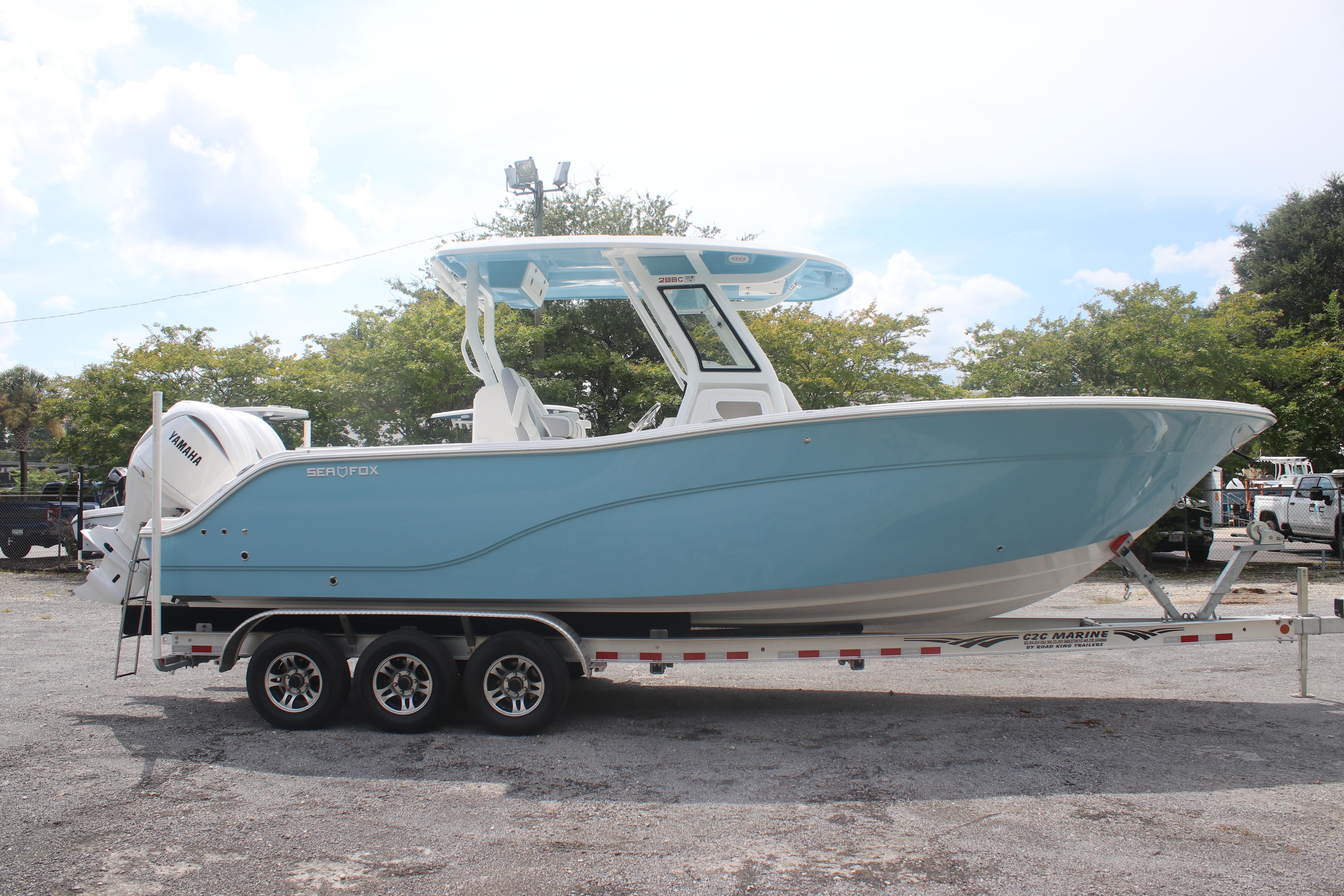 2026 Sea Fox 288 Commander boat on trailer, light blue hull, parked outdoors.