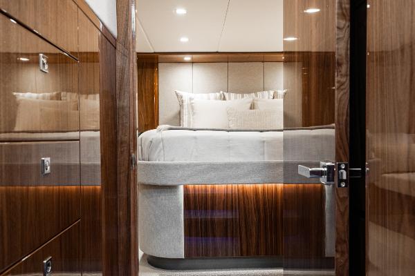 Luxurious bedroom interior of 2021 Riviera 5400 Sport Yacht with modern lighting.