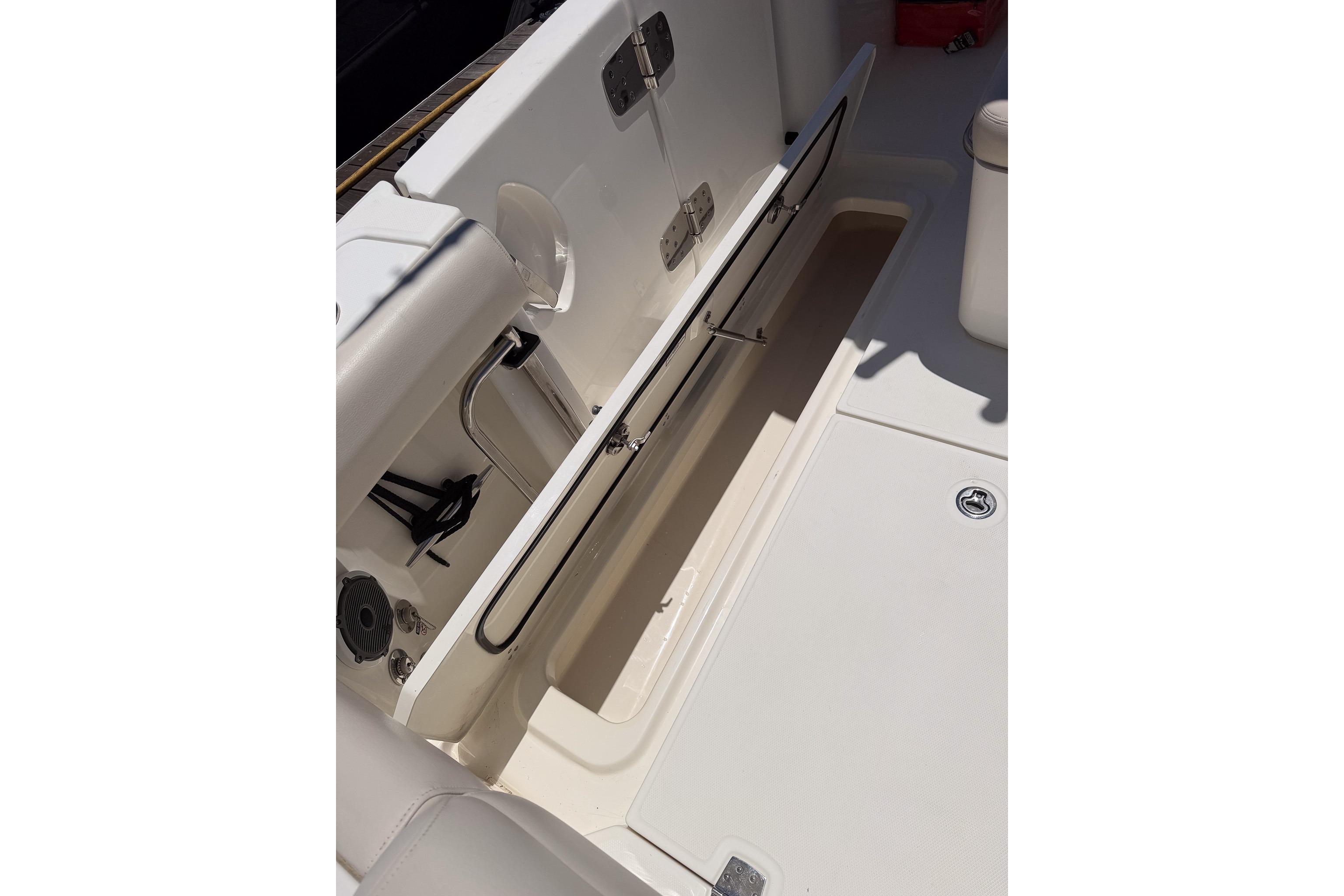2021 Boston Whaler 330 Outrage boat storage compartment with open hatch.