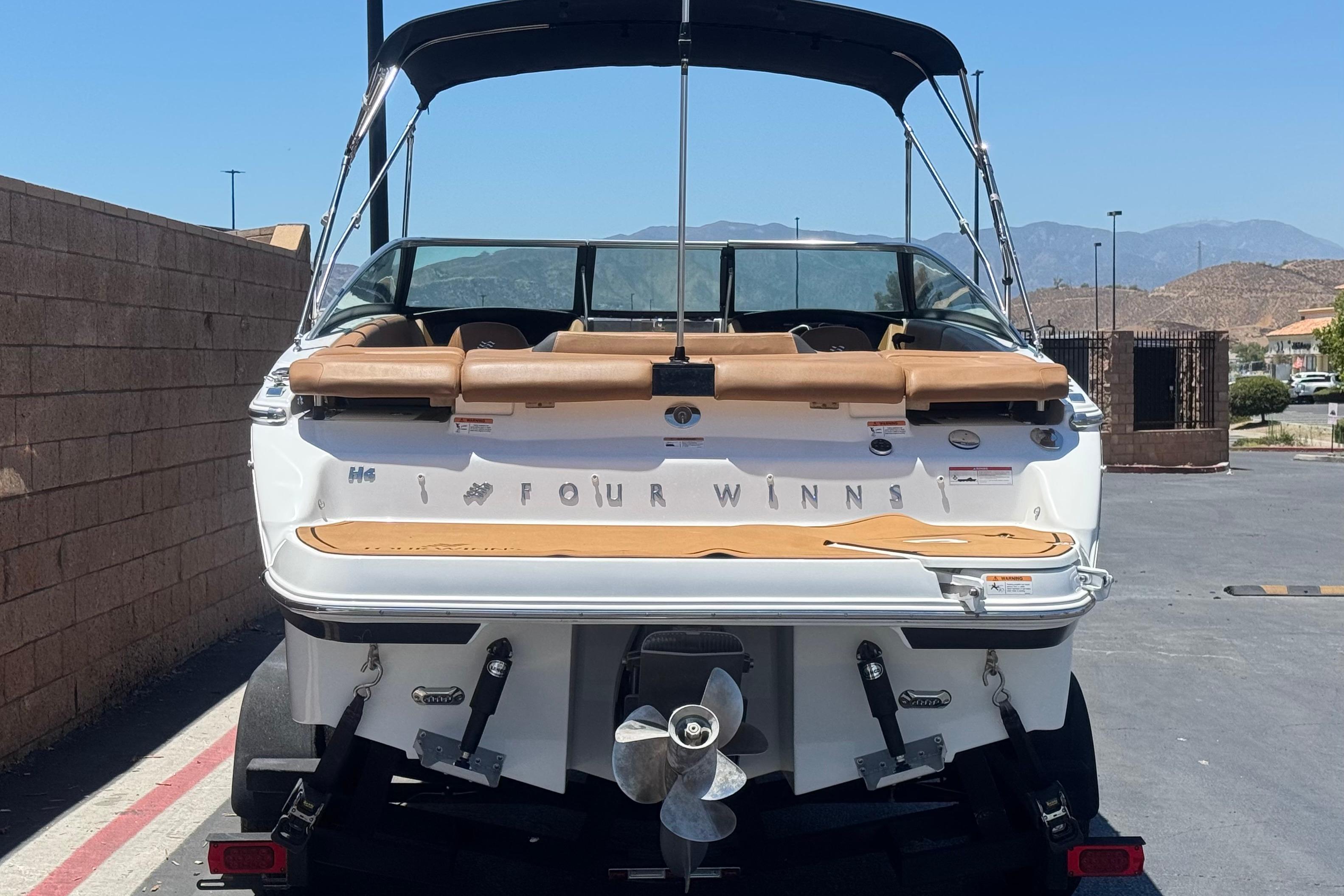 2022 Four Winns H4 boat, rear view, parked outdoors with mountains in the background.