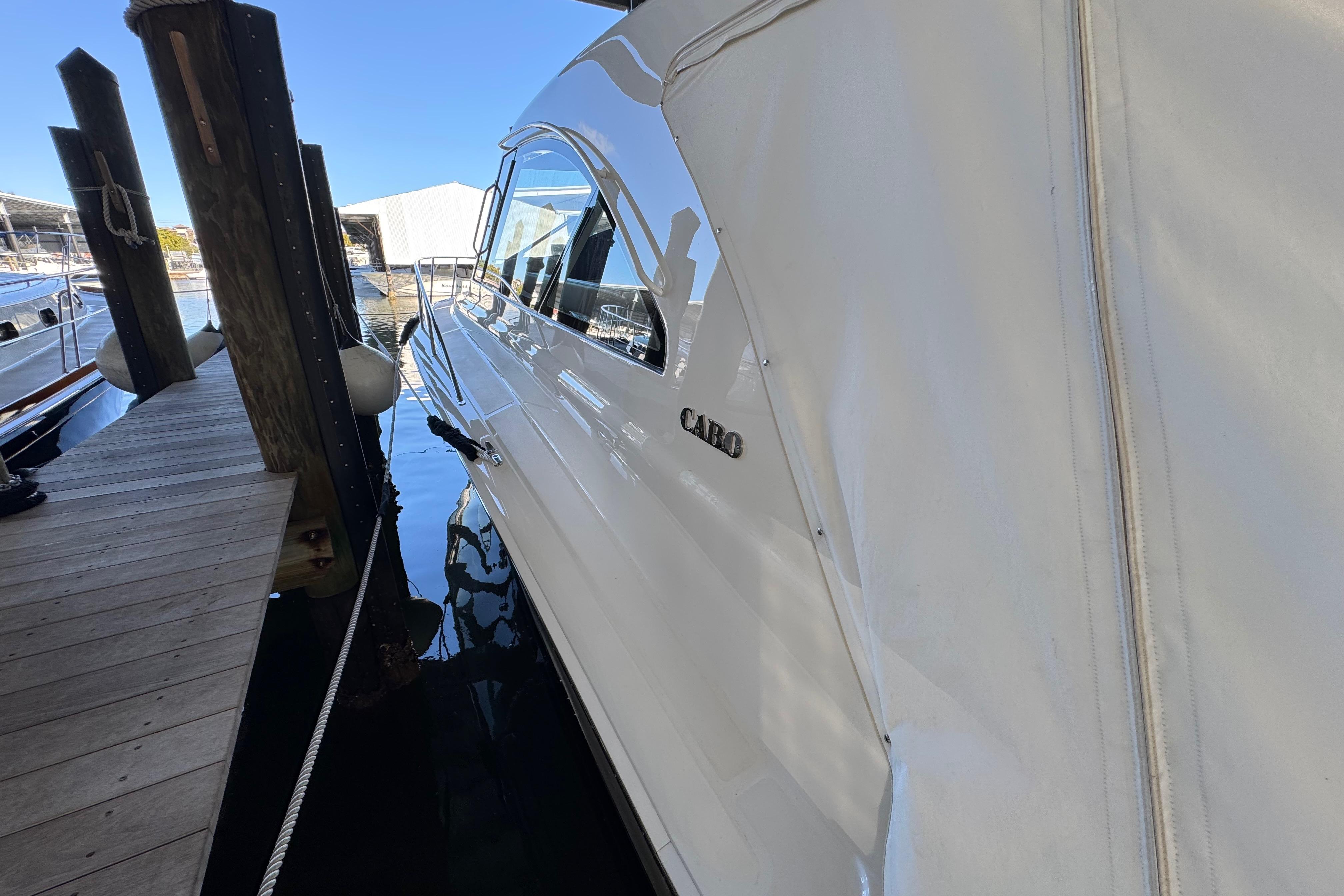 2013 Cabo 44 Hardtop Express yacht docked at marina.