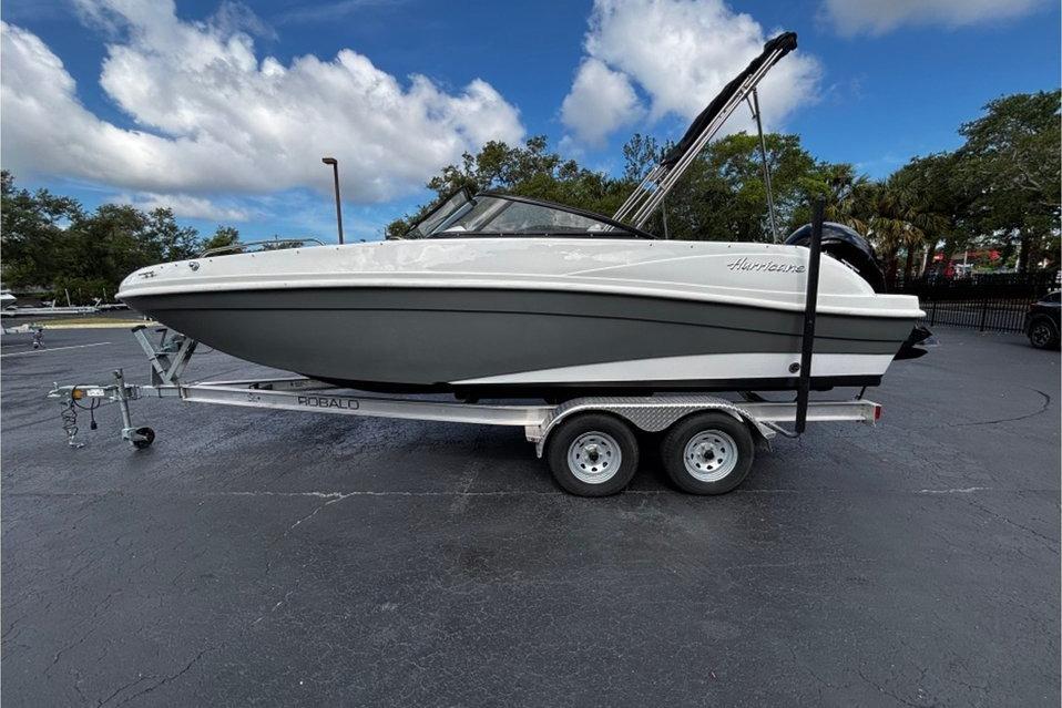 2022 Hurricane SunDeck 217 OB boat on trailer under a partly cloudy sky.