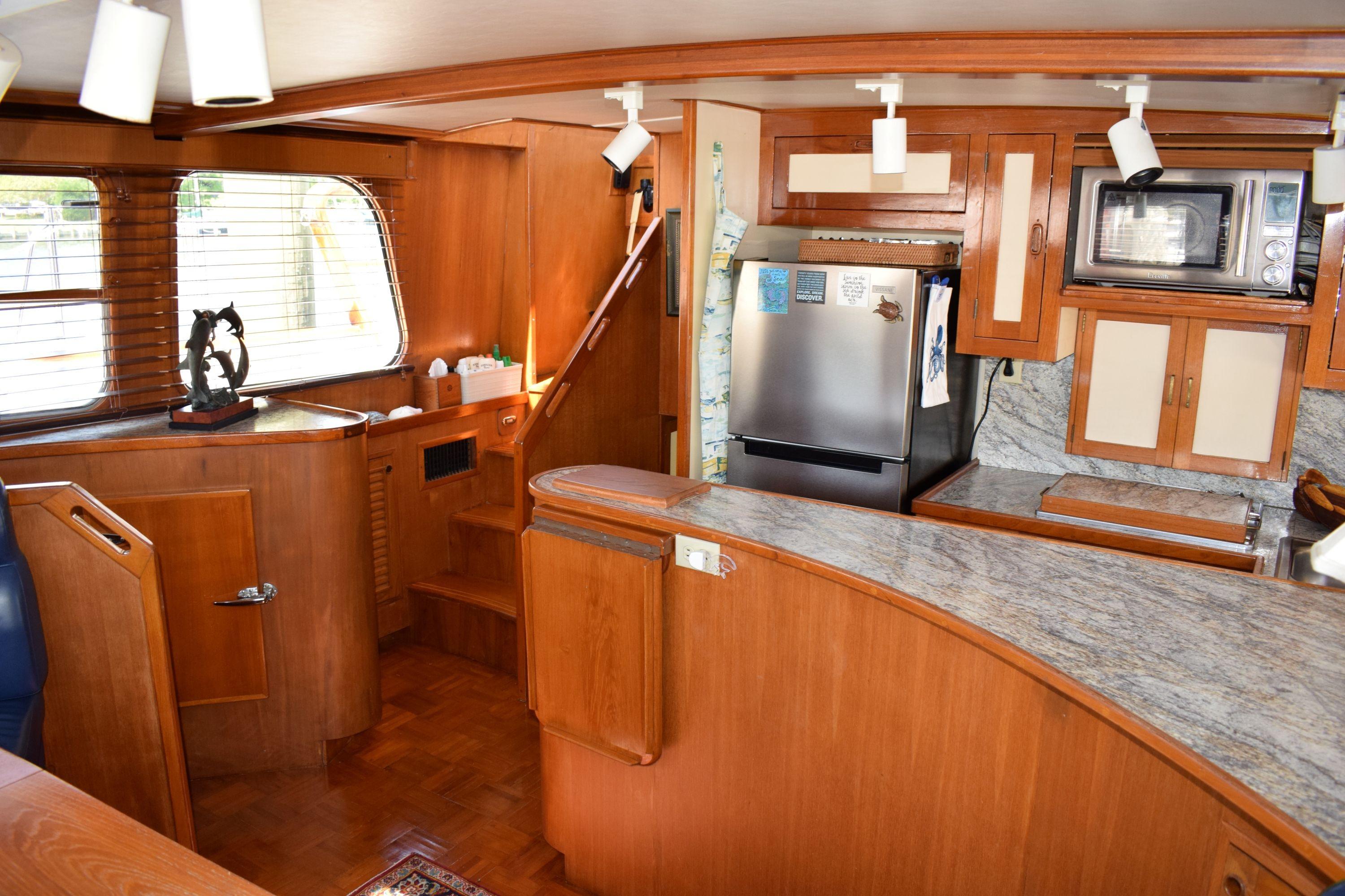 Interior of 1980 Cheoy Lee 52 Motorsailer with wooden cabinetry and modern kitchen appliances.