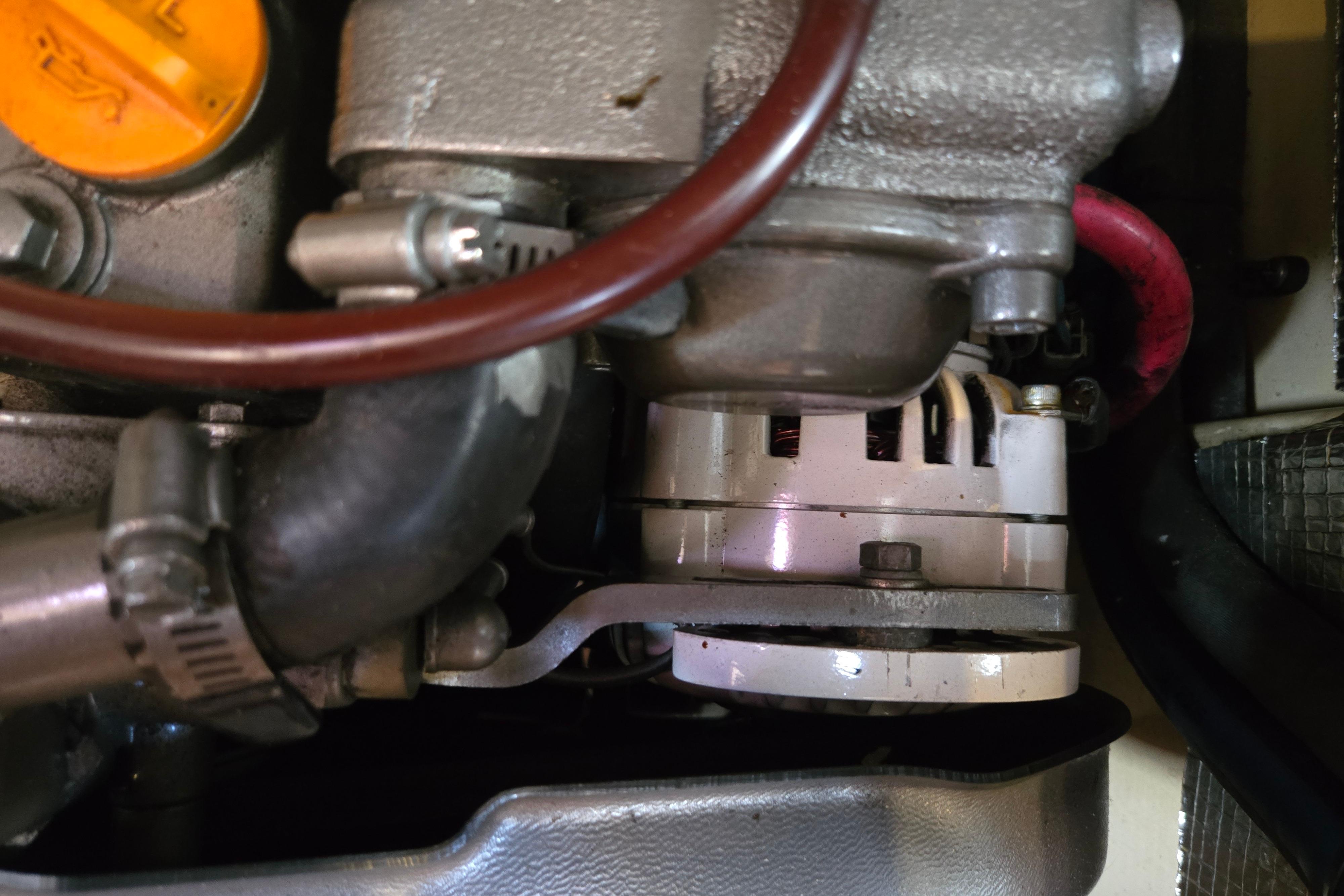 Engine components of a 2006 Island Packet 370 sailboat, featuring hoses and metal parts.