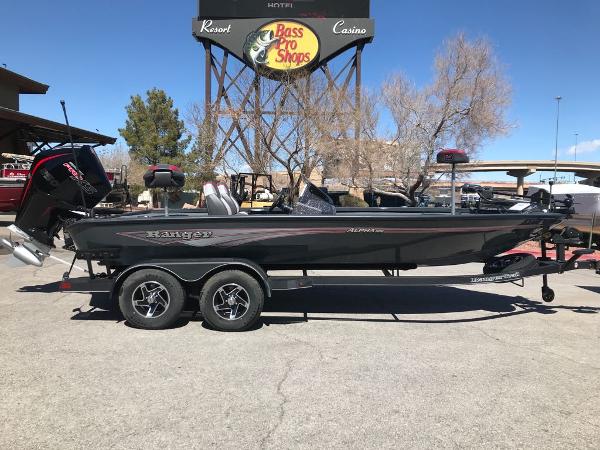 2025 Ranger ALPHA 208 boat parked at Bass Pro Shops, featuring dual-axle trailer.