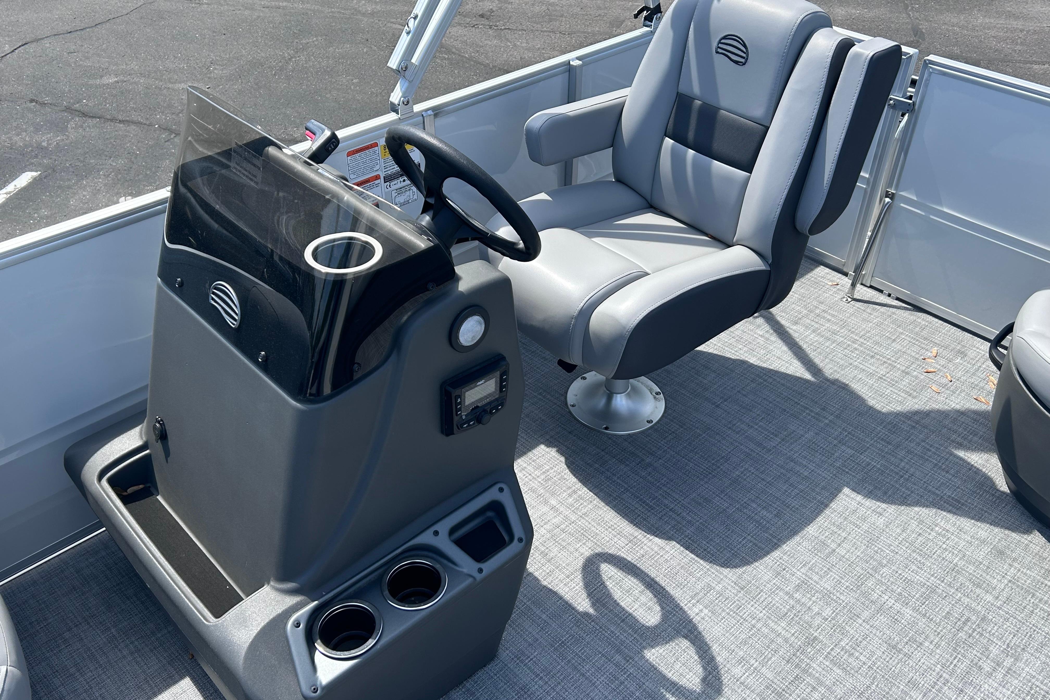 2026 Sun Tracker Party Barge 16 DLX interior with steering console and captain's chair.
