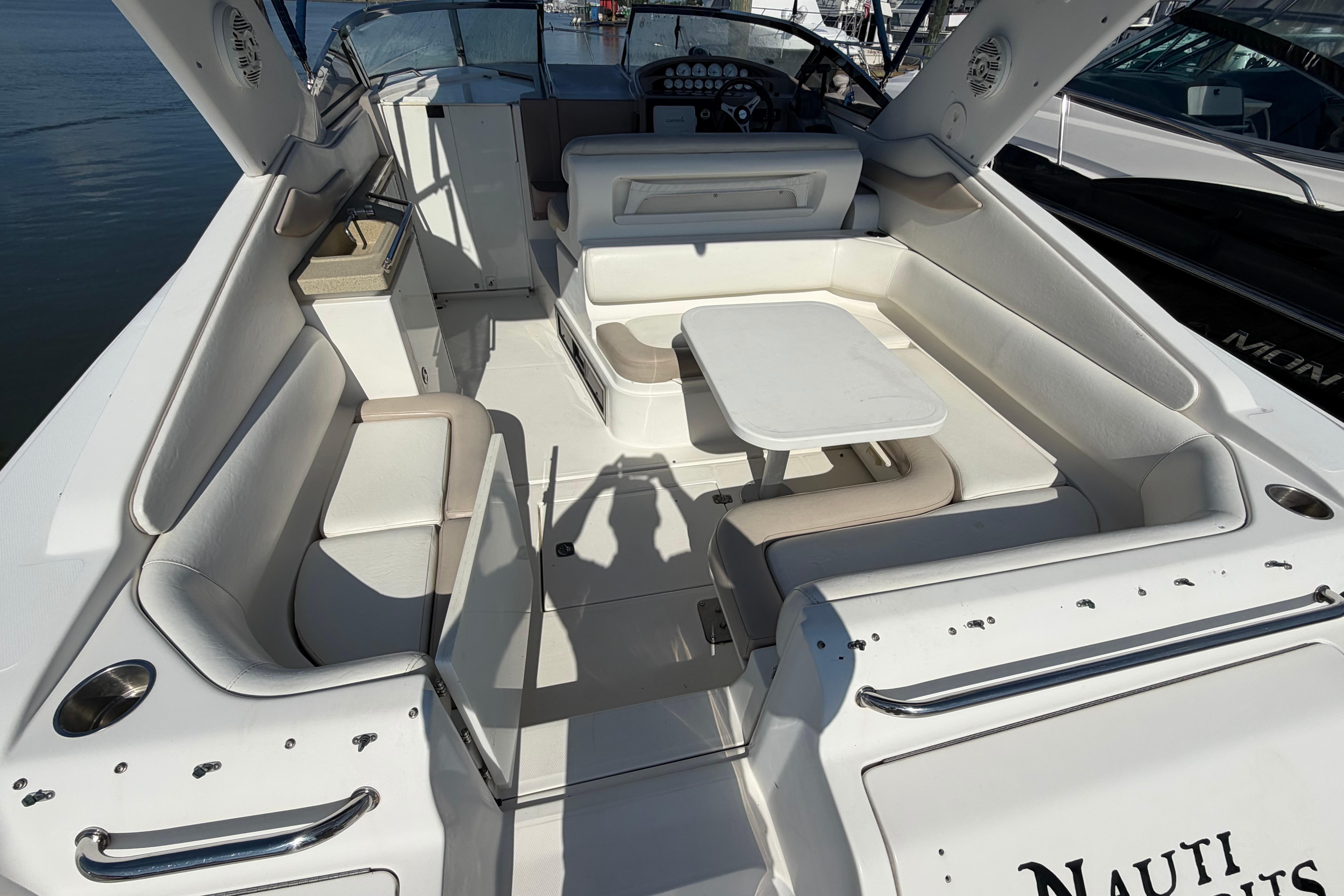 2003 Regal Commodore 3260 boat interior with white seating and table, docked at marina.