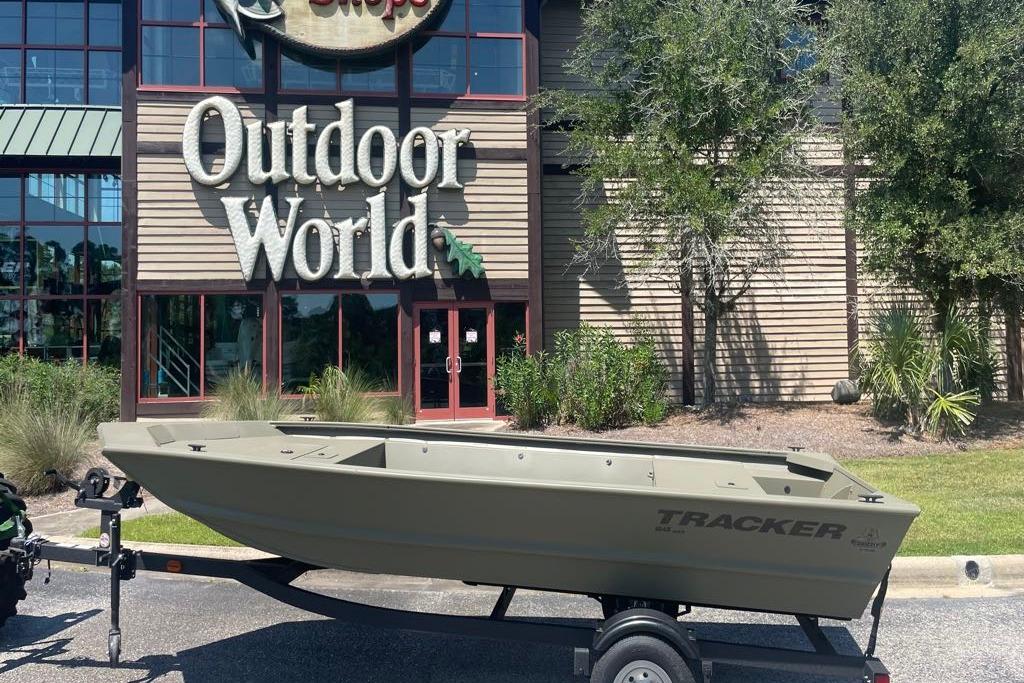 2026 Tracker Grizzly 1648 Utility boat on trailer outside Outdoor World store.