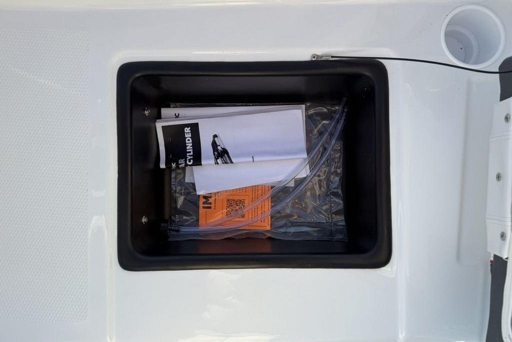 Storage compartment of 2026 Tahoe T16 boat with manuals and documents.