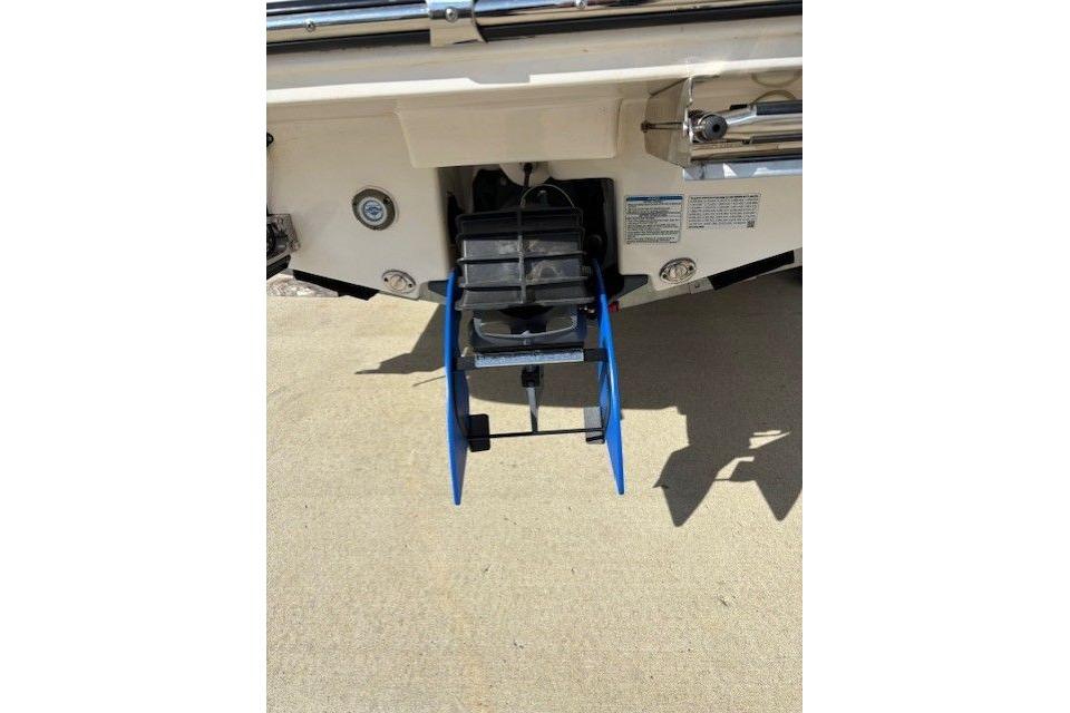 Rear view of 2022 Yamaha Boats 195 FSH Deluxe with blue ladder extended.