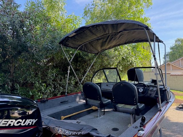 A 2023 Tracker PGV16WT 16 boat with a black bimini top and two seats.