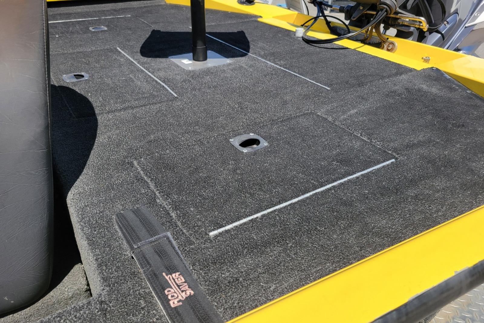 Carpeted deck of a 2011 Excel 1751 F4 boat with rod holder.