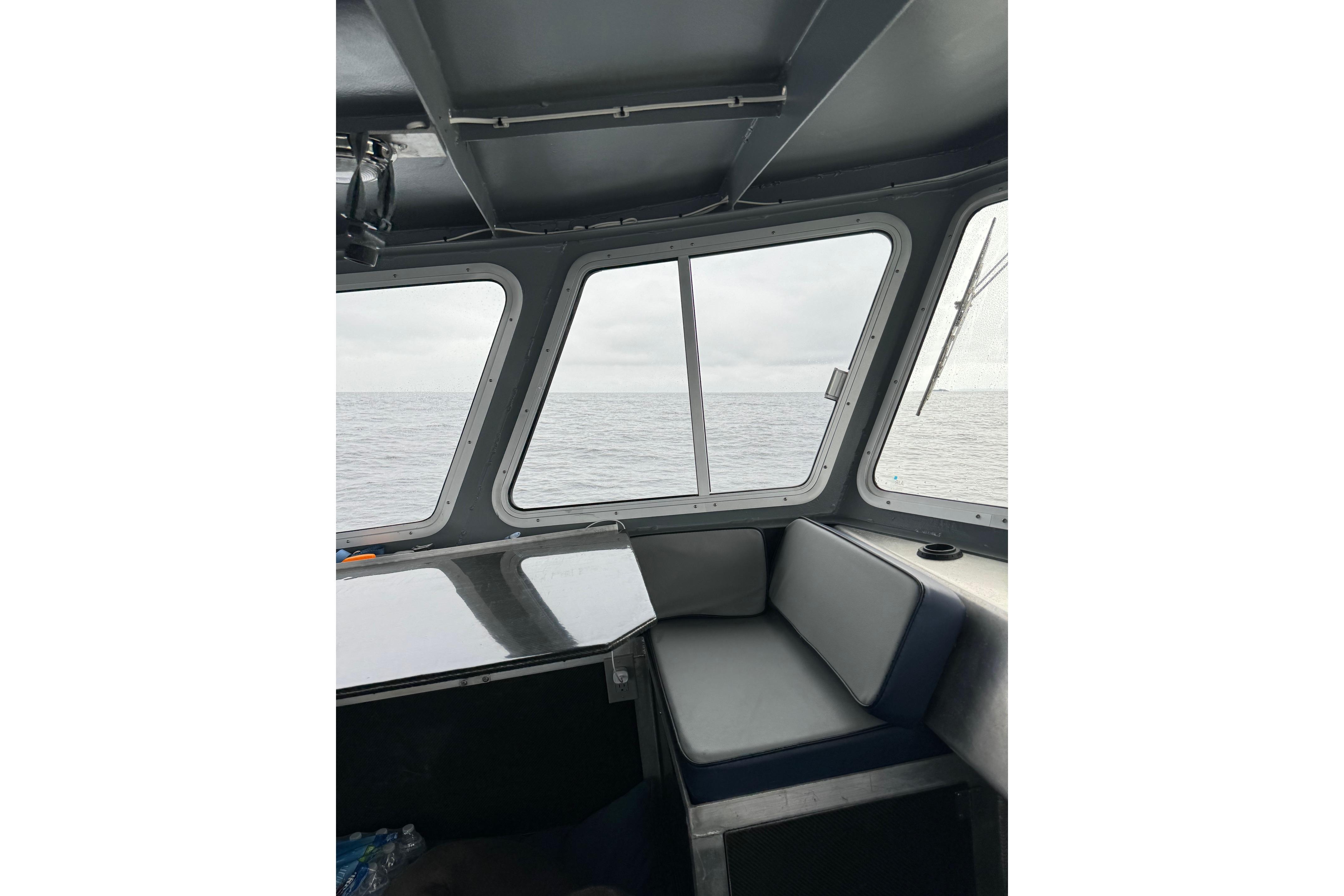 Interior view of 2021 Custom Aluminum Crabber boat with ocean through windows.