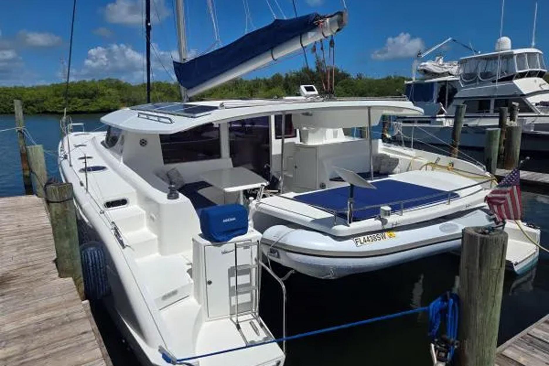 2008 Fountaine Pajot Salina 48 catamaran docked, featuring spacious deck and American flag.