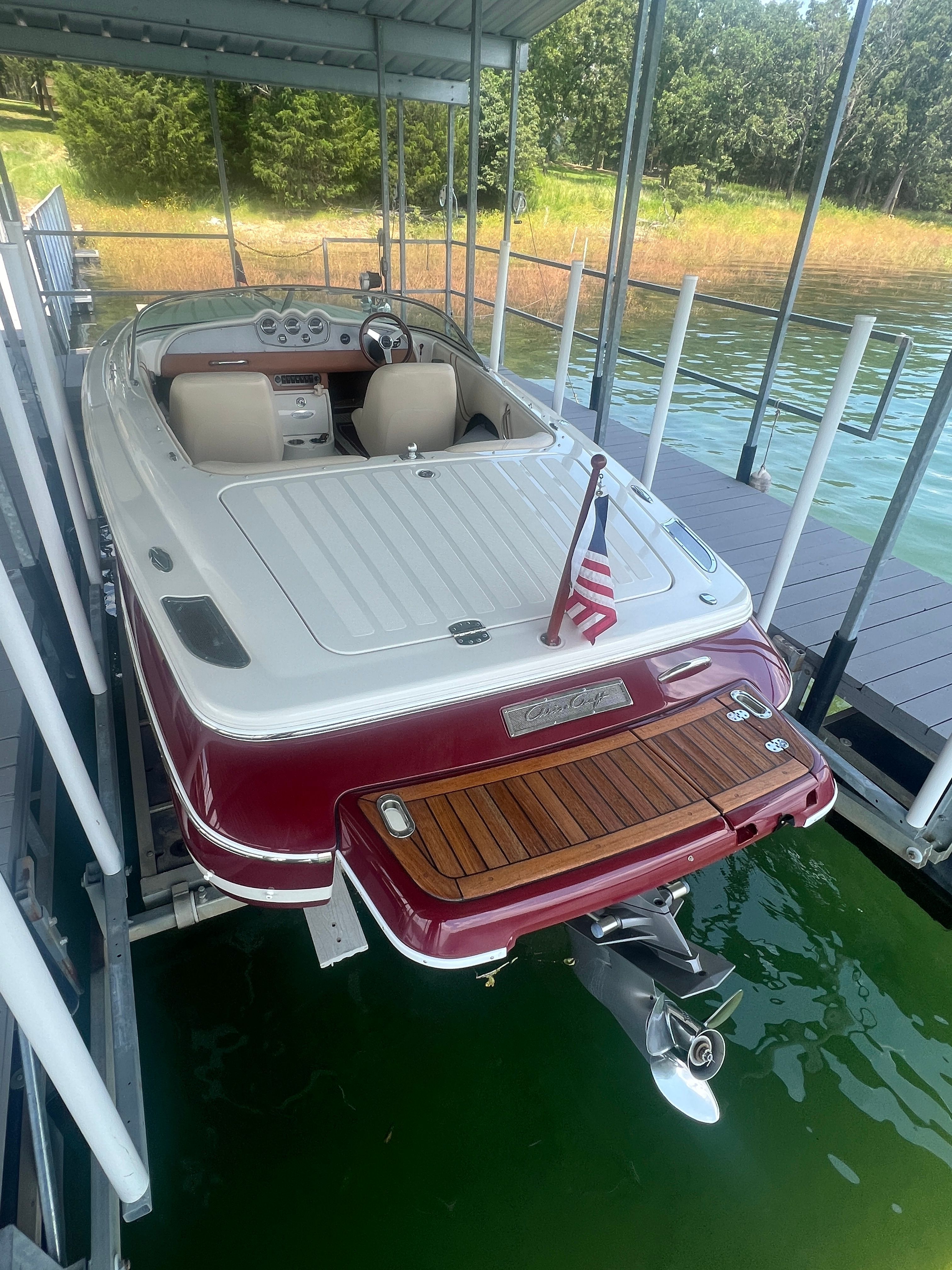 A 2006 Chris-Craft Speedster 20 docked. It features a sleek design with red accents.