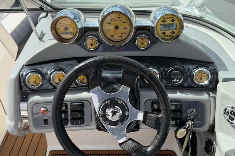Dashboard of a 2004 MasterCraft XStar boat with gauges and steering wheel.
