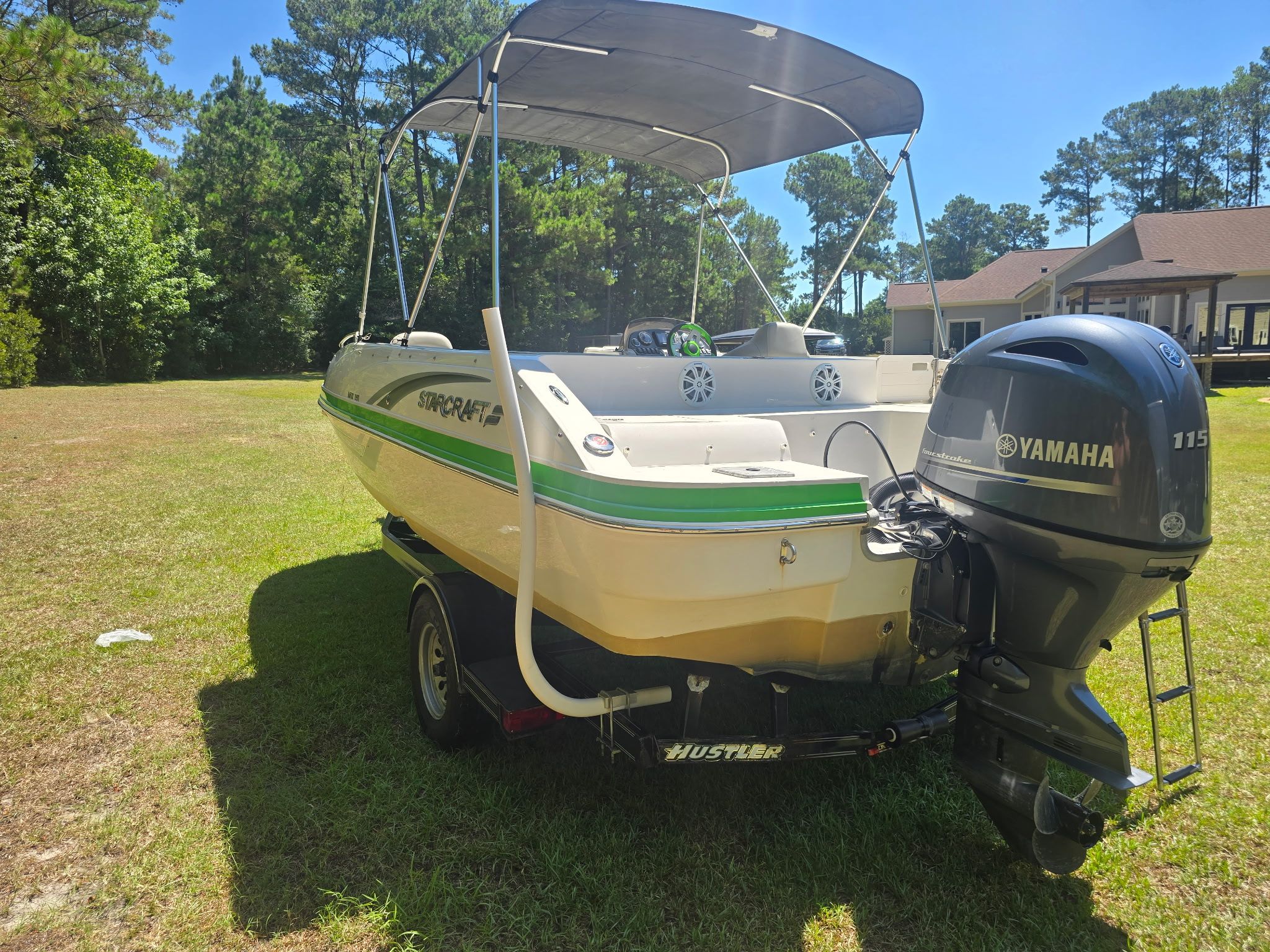 A 2017 Starcraft MDX 191 OB boat on a trailer on a grassy area.