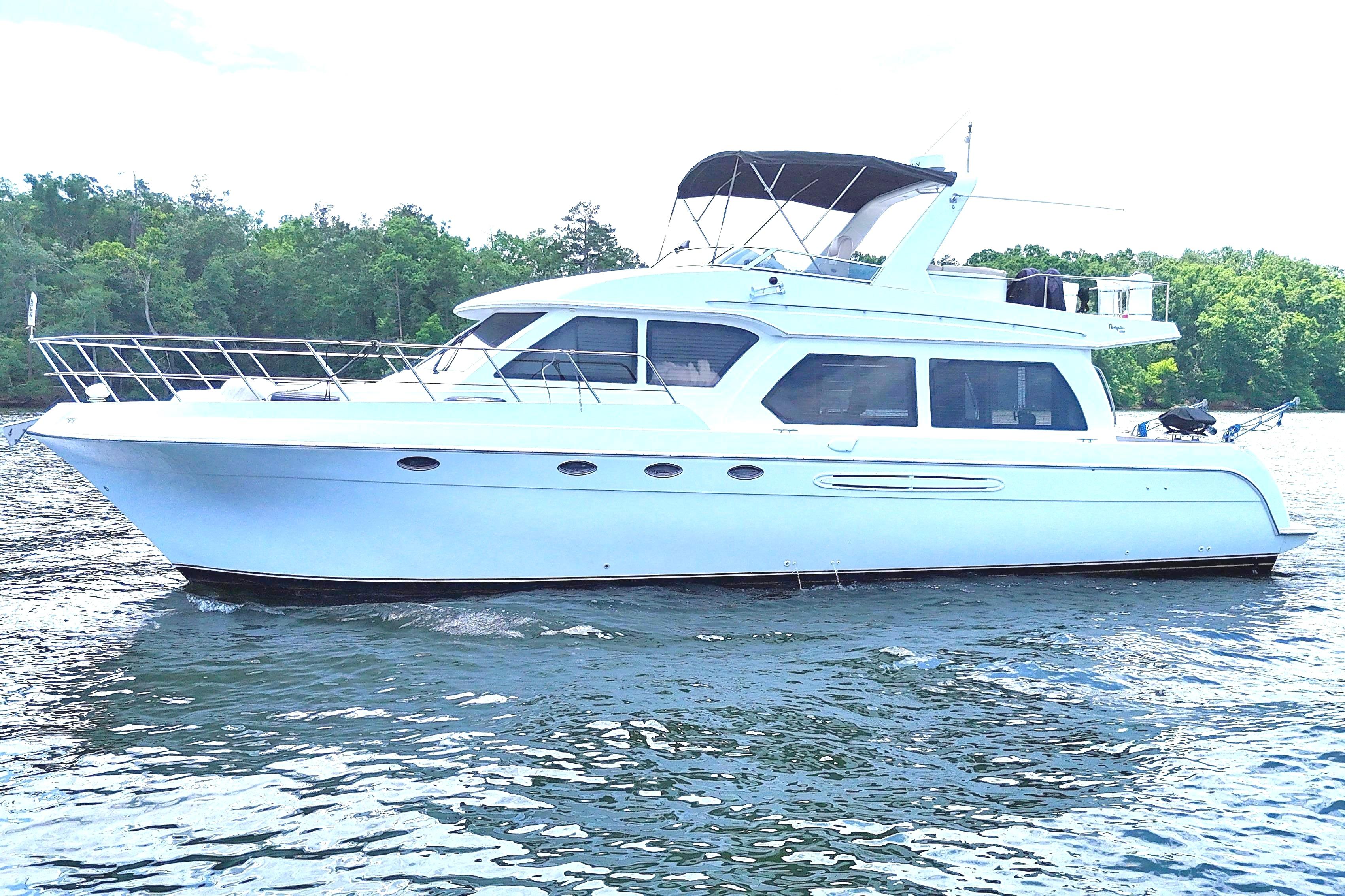 2007 Navigator 5100 yacht on a serene lake with lush green shoreline.