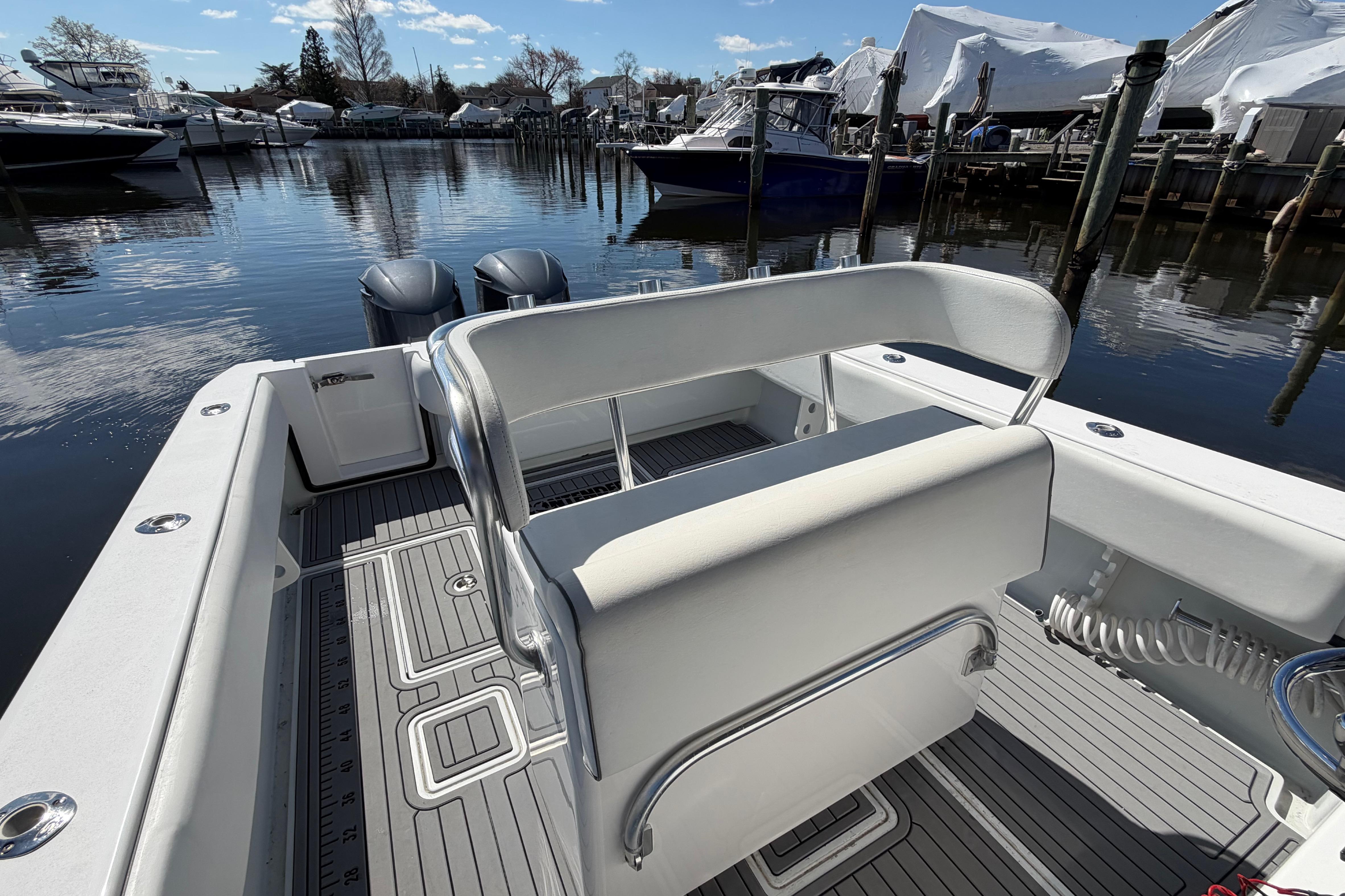 2015 Contender 32 ST boat interior with dual engines, docked in a marina.