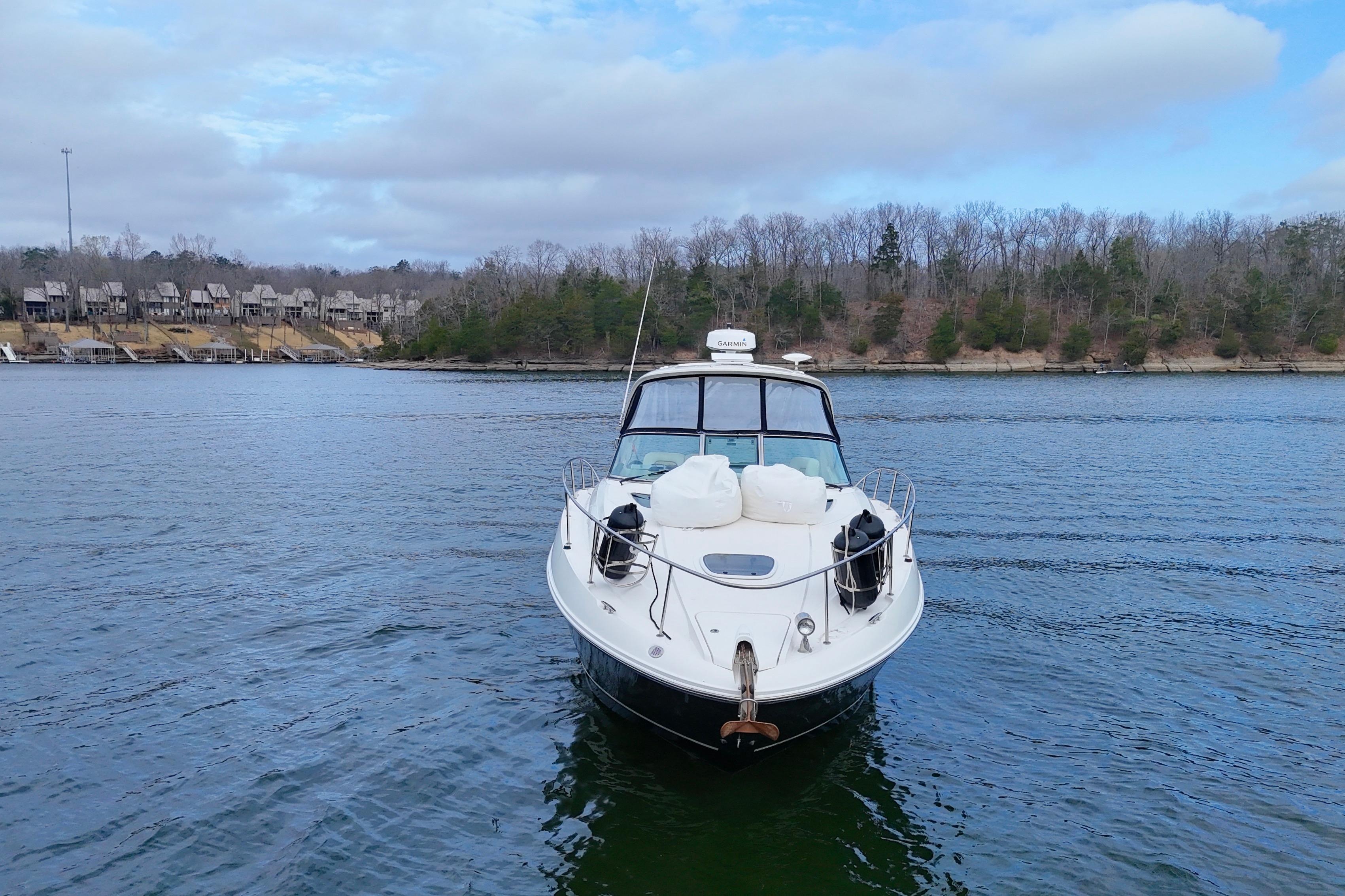 2009 Sea Ray Sundancer 350 yacht on a calm lake with wooded shoreline.