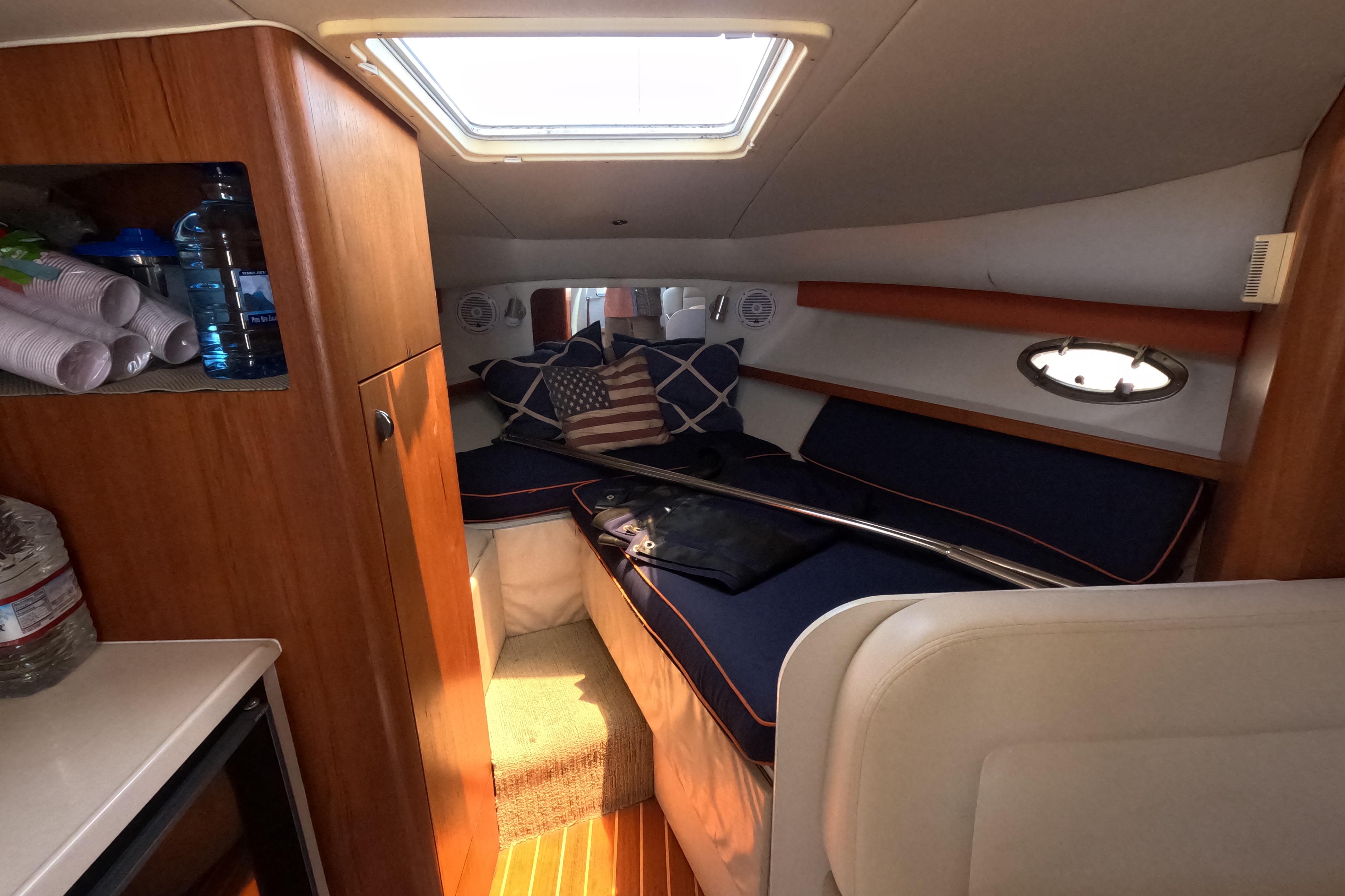 1995 Tiara Yachts 2900 Open cabin interior with cozy bedding and wooden cabinetry.
