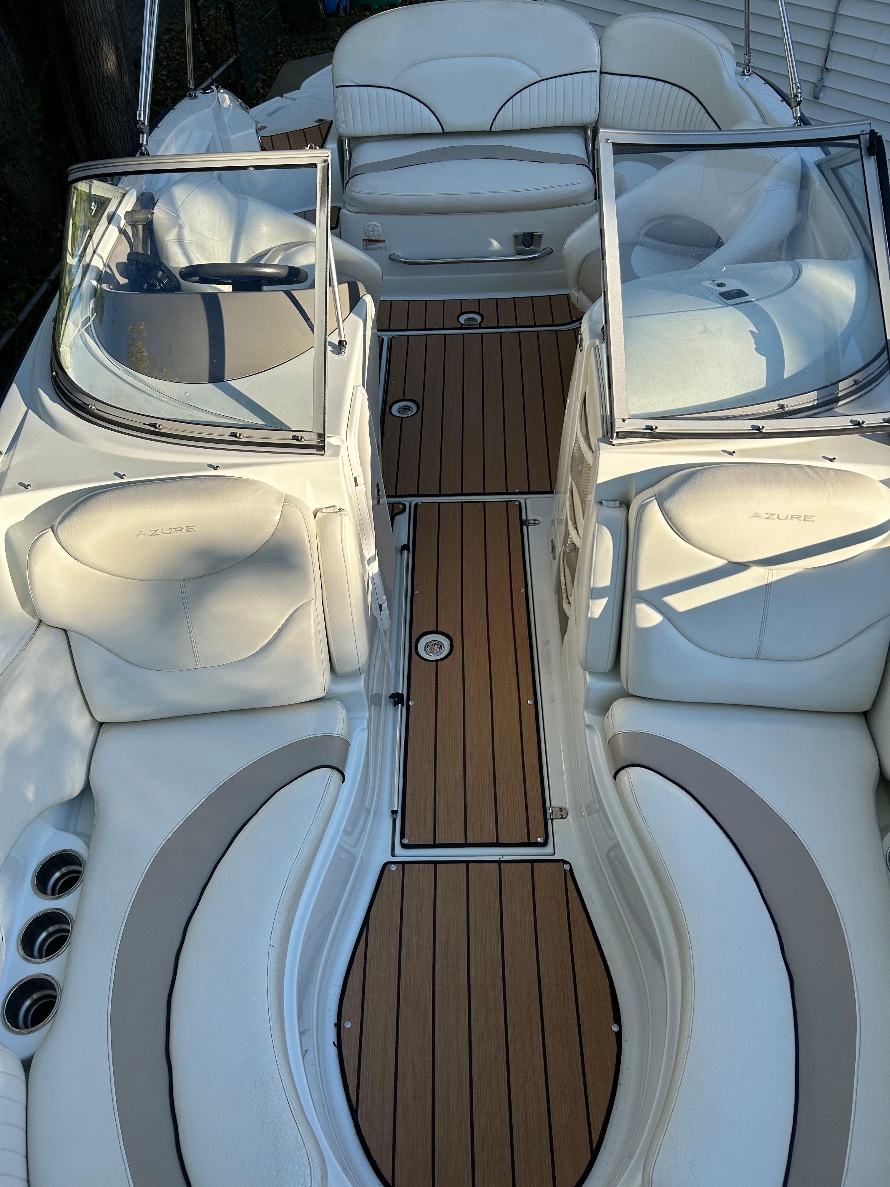 The image shows the cockpit of a 2008 Azure AZ220 boat with white seating and wood flooring.