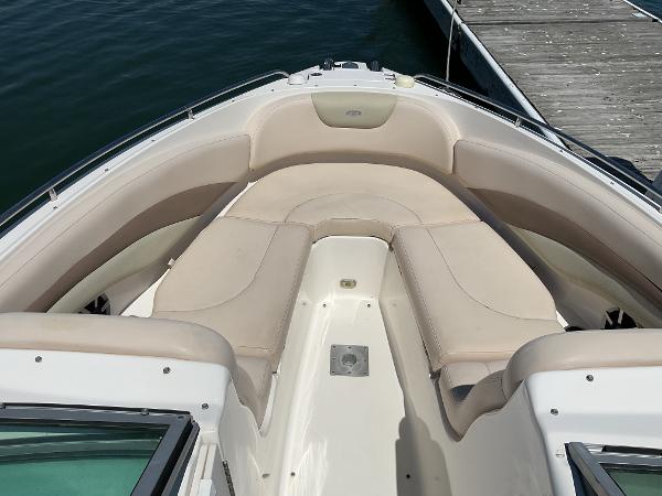 2006 Chaparral 256 SSi boat with beige seating, docked by the water.