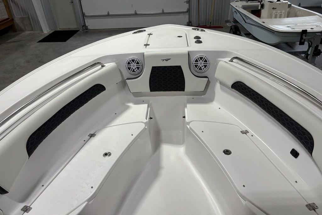 2026 Tidewater 232 CC Adventure boat interior with seating and speakers in a garage.