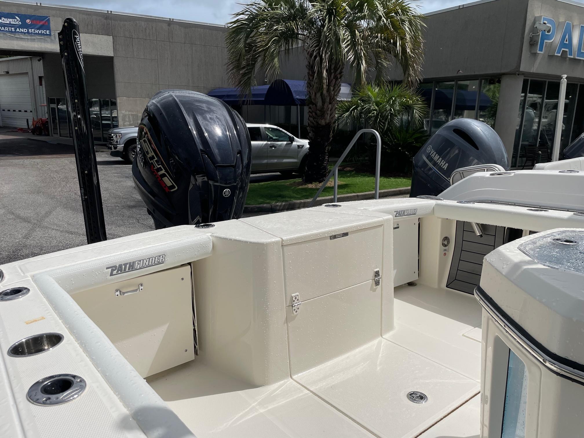 2024 Pathfinder 2400 Open boat with dual outboard motors, docked near dealership.