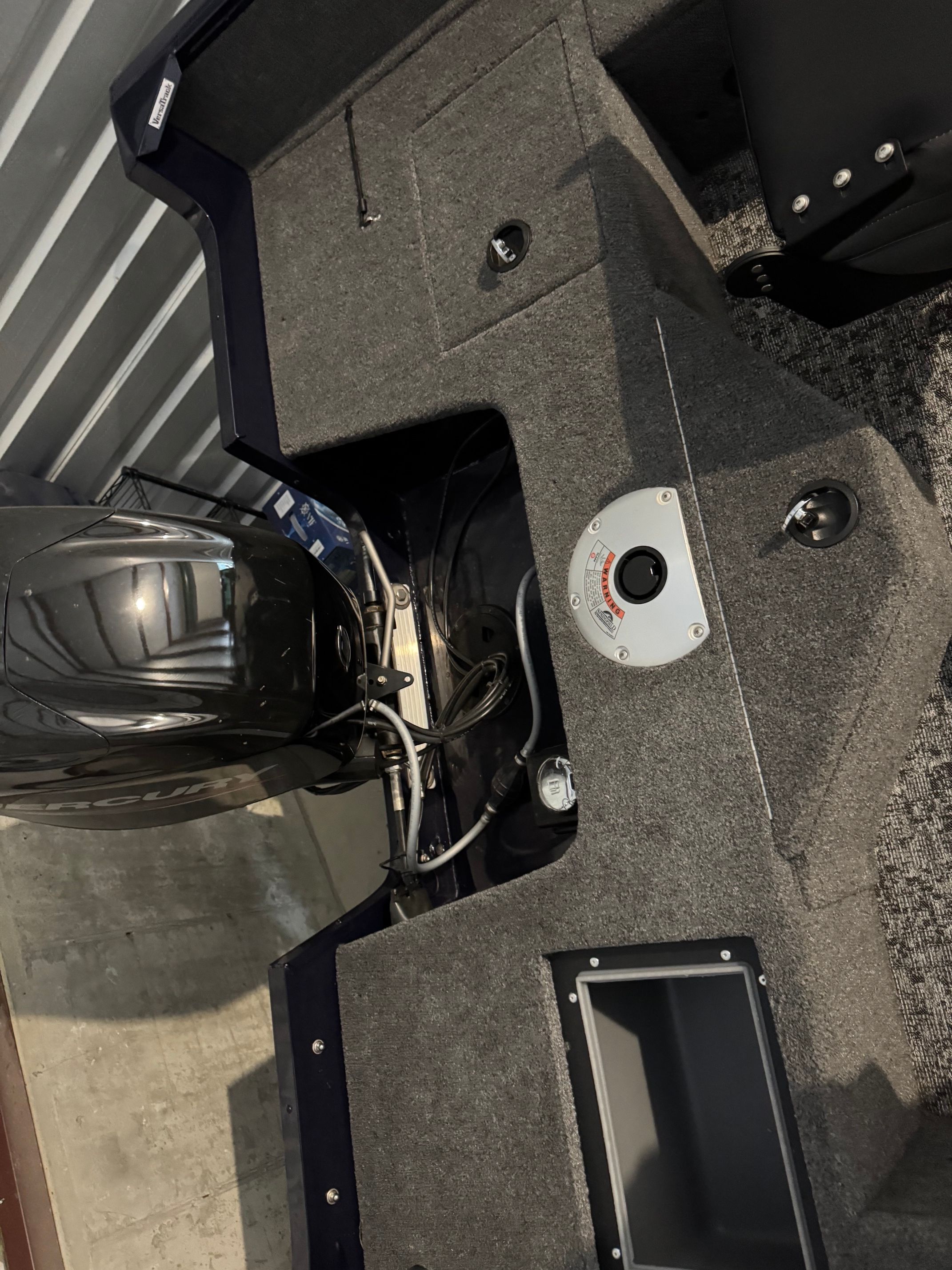 Interior view of a Tracker Pro Guide V-16 SC boat with gray carpeting and engine.
