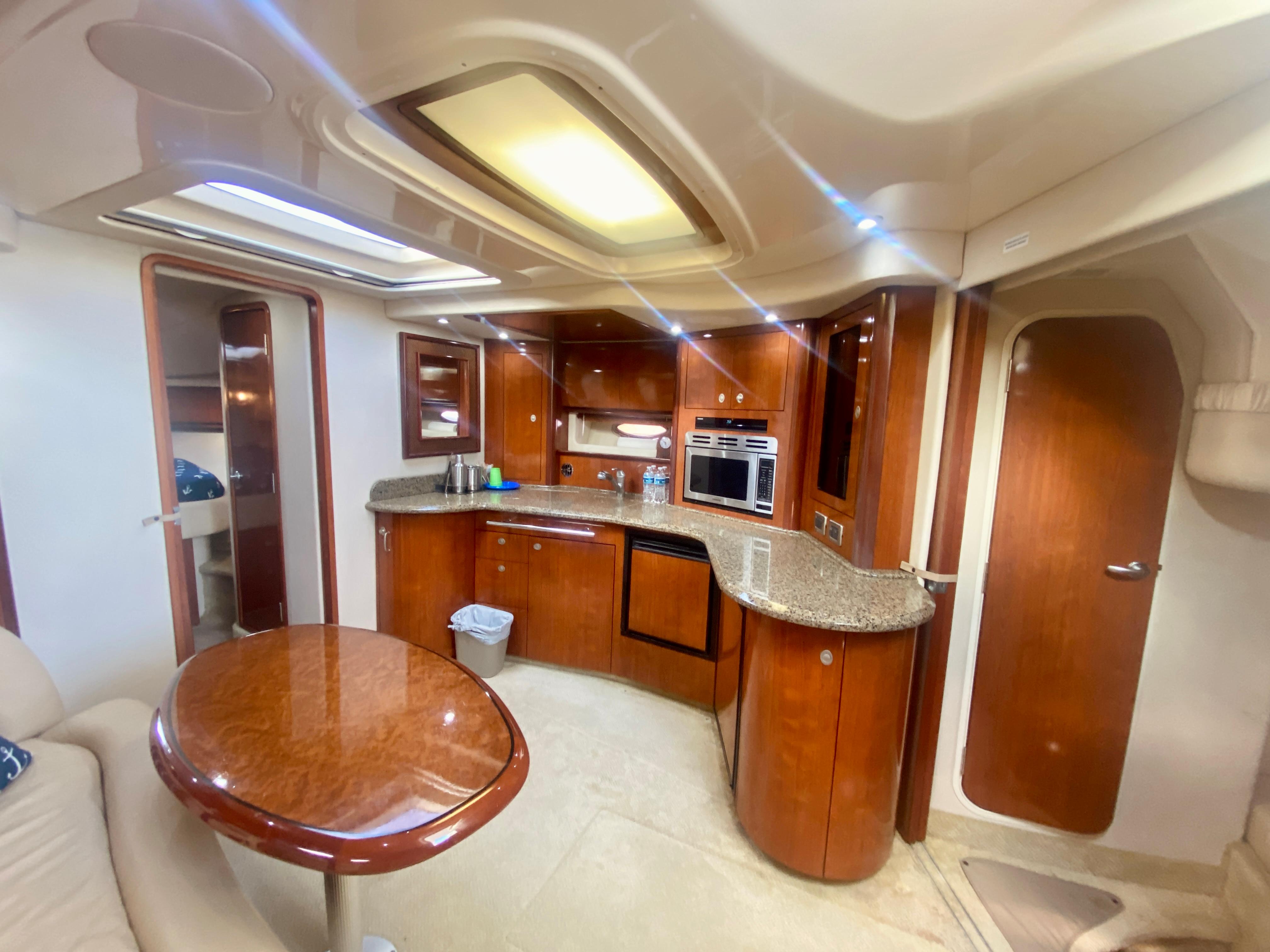 Luxurious interior of 2005 Sea Ray 420 Sundancer yacht with modern kitchen and dining area.