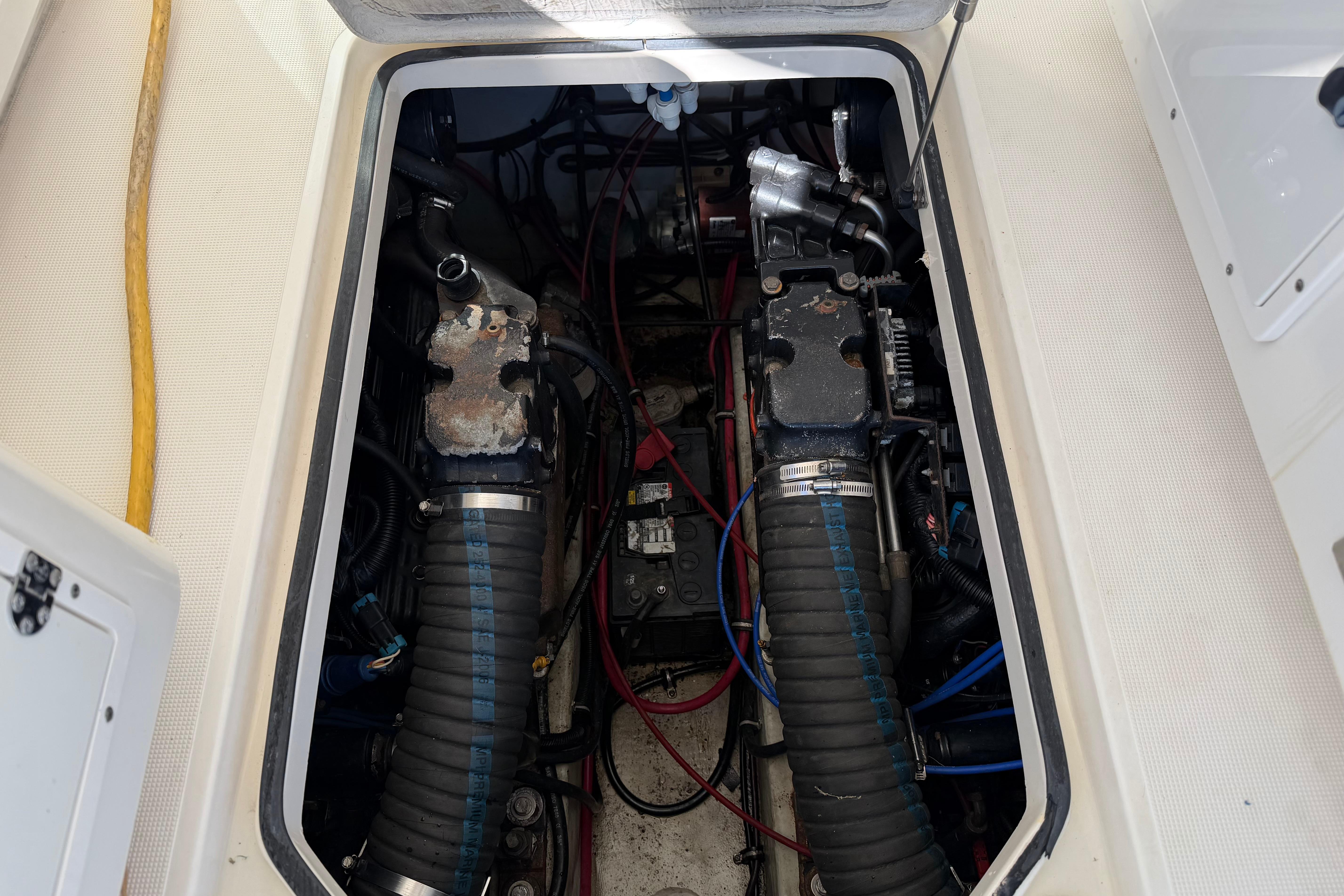 Engine compartment of a 2001 Pursuit 3000 Express boat, showing mechanical components and wiring.