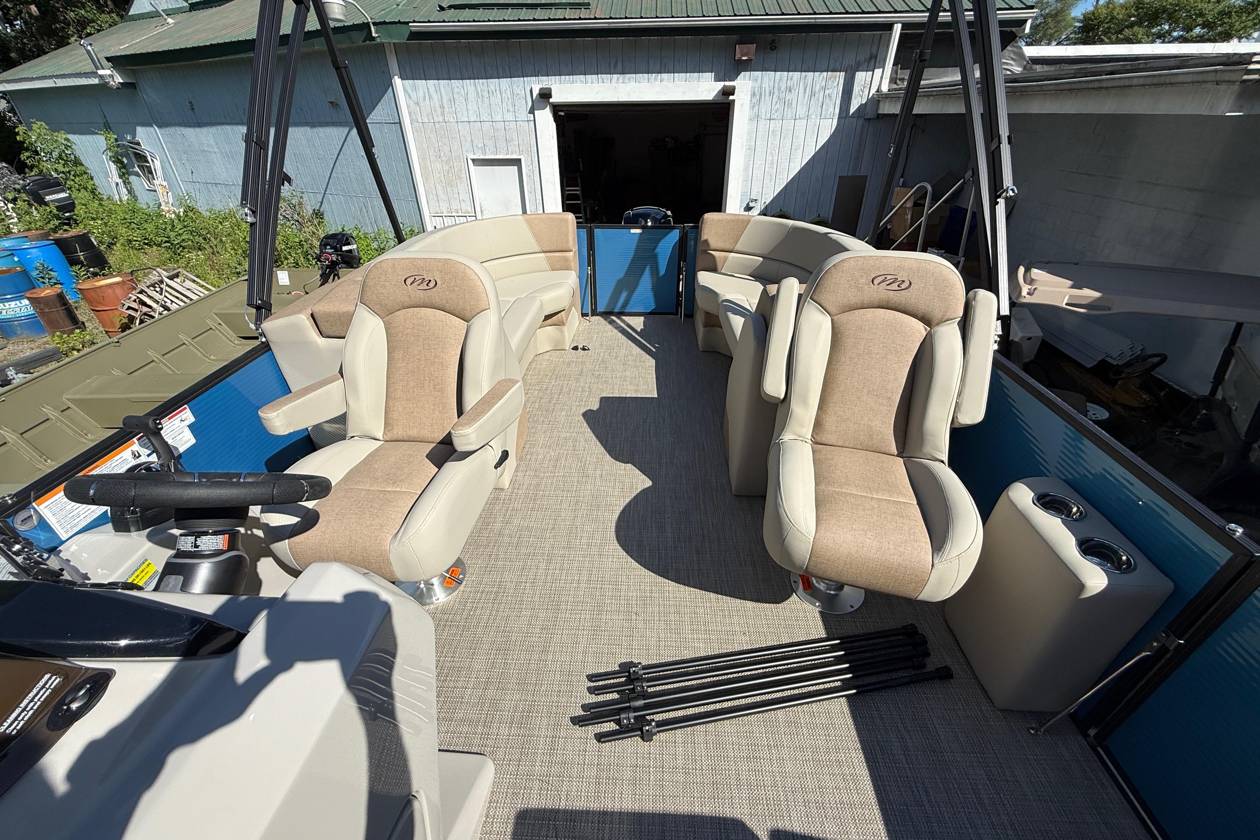 2027 Manitou Aurora RF 23 pontoon boat interior with plush seating and steering console.